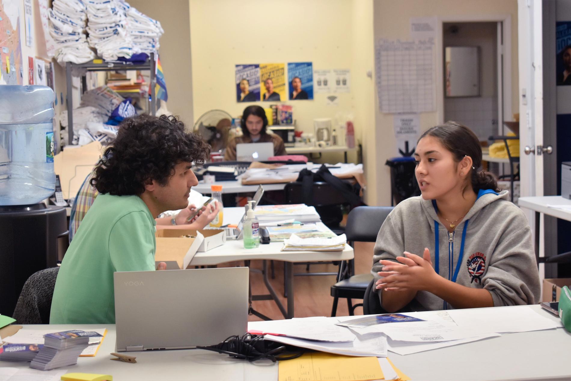 Bilal Tahir, som organiserar dörrknackning för den demokratiska kongressledamotskandidaten Alexandria Ocasio-Cortez, diskuterar jämställdhet med gymnasiestudenten Isabela Buitrago på kampanjkontoret i Queens i New York.