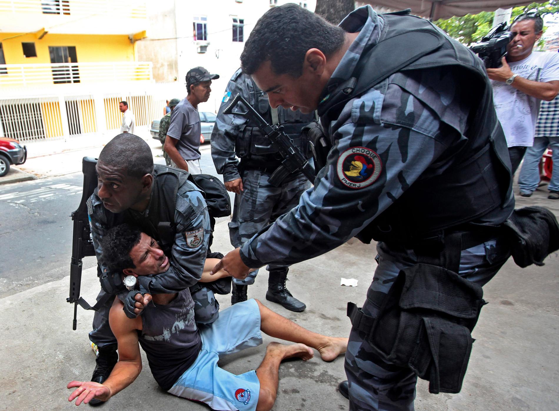Polis förhör en man i Rio de Janeiro.