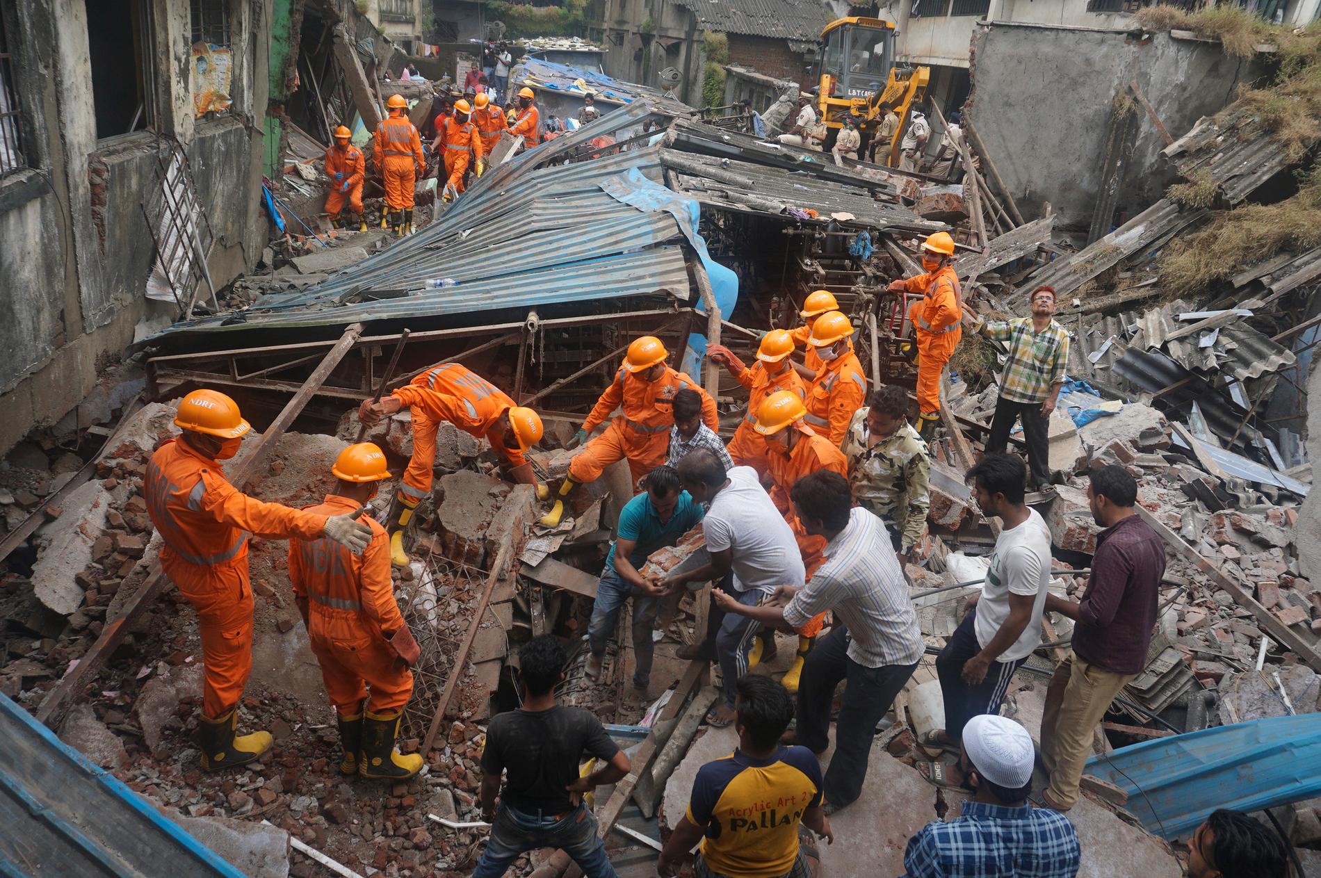 Indiska räddningsarbetare vid den kollapsade byggnaden.