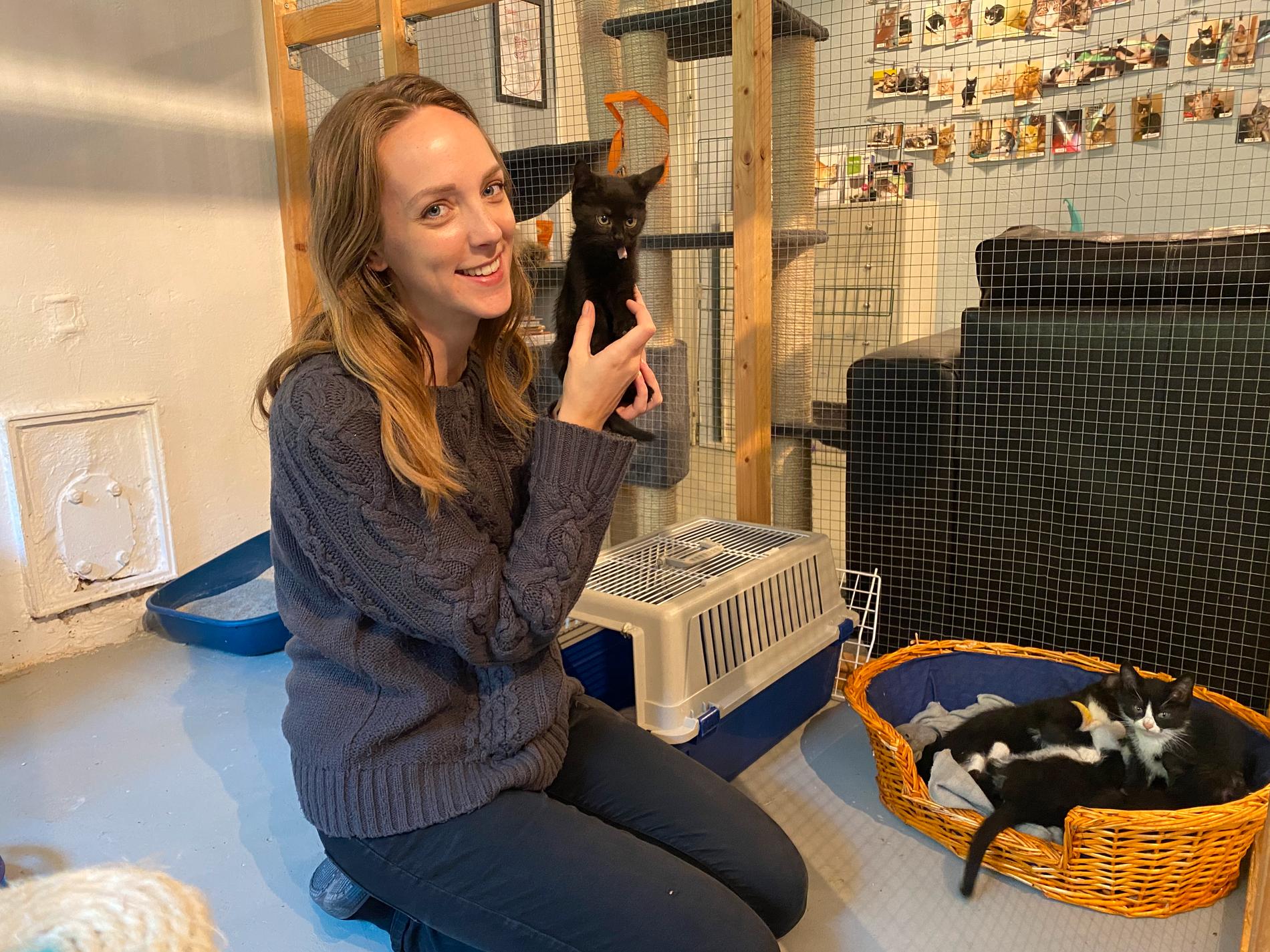 Volontären Laura tillsammans med en av de kattungar som föddes på Katthjälpen för några veckor sedan.