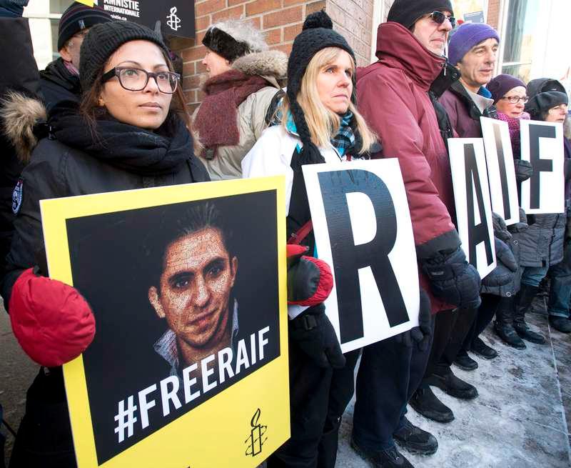 Ensaf Haidar håller upp ett porträtt på sin man Raif Badawi. Han är dömd till bland annat tusen piskrapp för att ha skrivit en liberal blogg. Saudiarabiens rättssystem bygger på en extrem tillämpning av islamisk traditionell straffrätt som inte hör hemma på 2000-talet – samtidigt som landet vill ha det moderna västerländska samhällets senaste teknik för krig och förödelse.