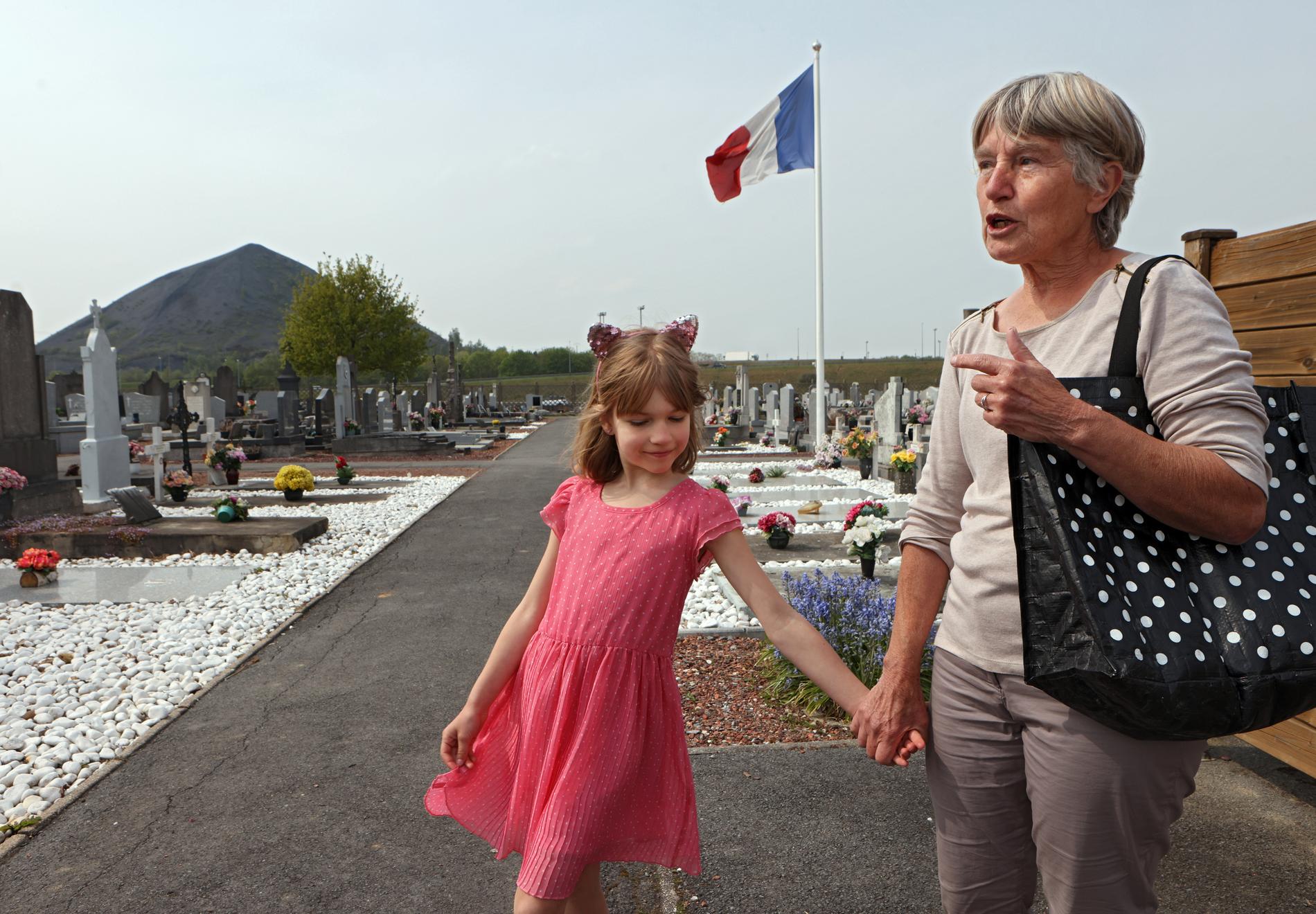  Dominique med barnbarnet Meline, 8 år tar hand om några franska soldaters gravar i utkanten av staden.