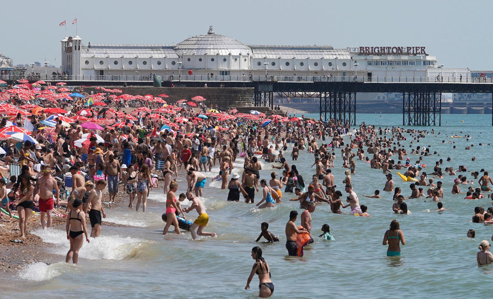 Människor trängdes på stranden i Brighton på tisdagen, då flera platser i Storbritannien noterade temperaturer på över 40 grader.