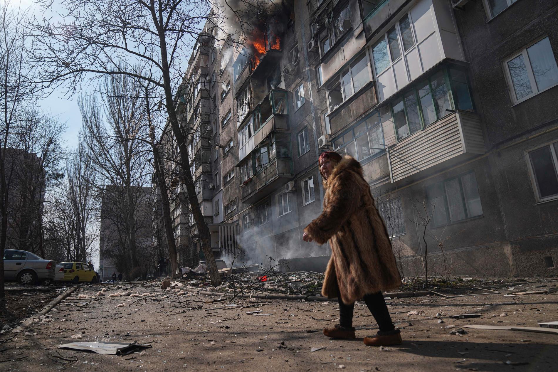 En kvinna går förbi en byggnad i Mariupol 14 mars.