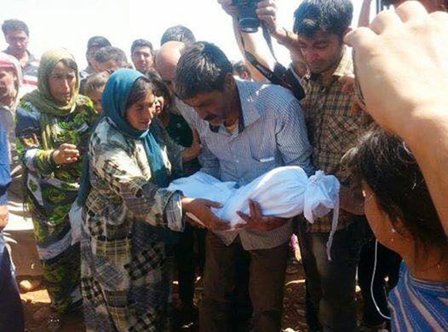 Alans pappa, Abdullah Kurdi, håller honom i armarna för sista gången.