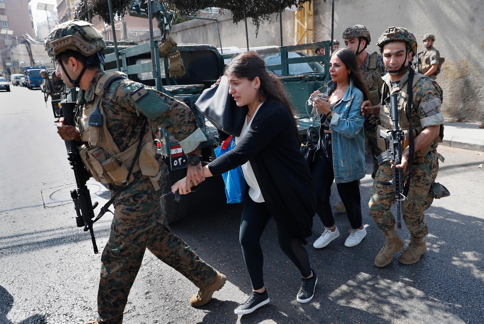 Libanesiska styrkor eskorterar lärare från en skola som hamnade i skottgluggen under den våldsamma sammandrabbningen. 