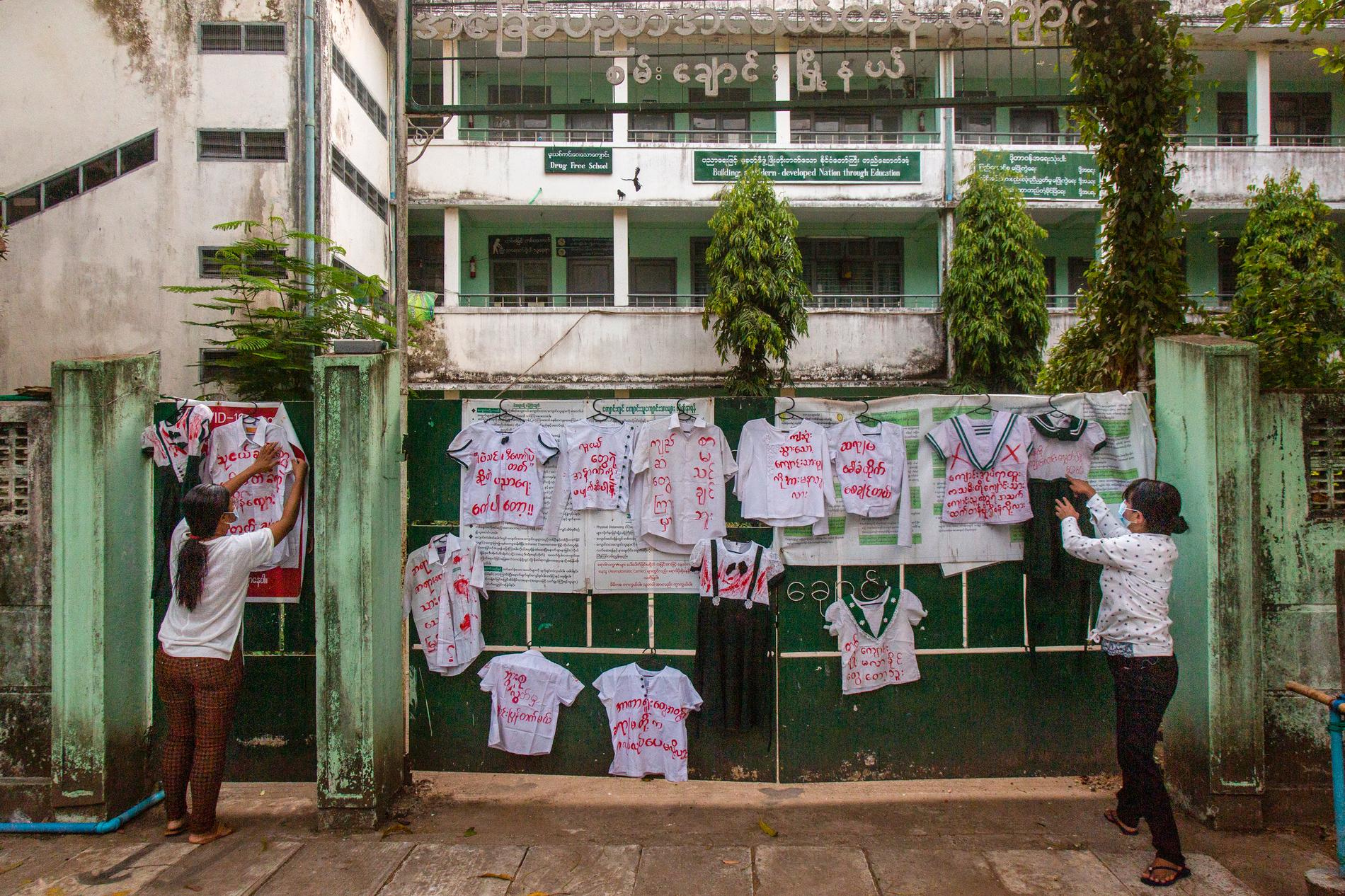 Demokratiaktivister hänger skoluniformer vid ingången till en skola under en protest i Rangoon i slutet av april.