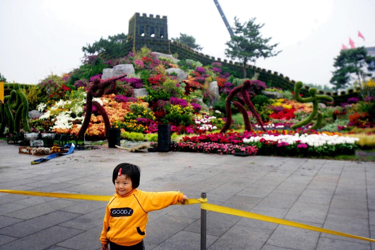 Det är populärt att fotografera sina nära och kära framför den gröna ”kinesiska muren”, som har byggts upp inför OS, på Himmelska fridens torg.