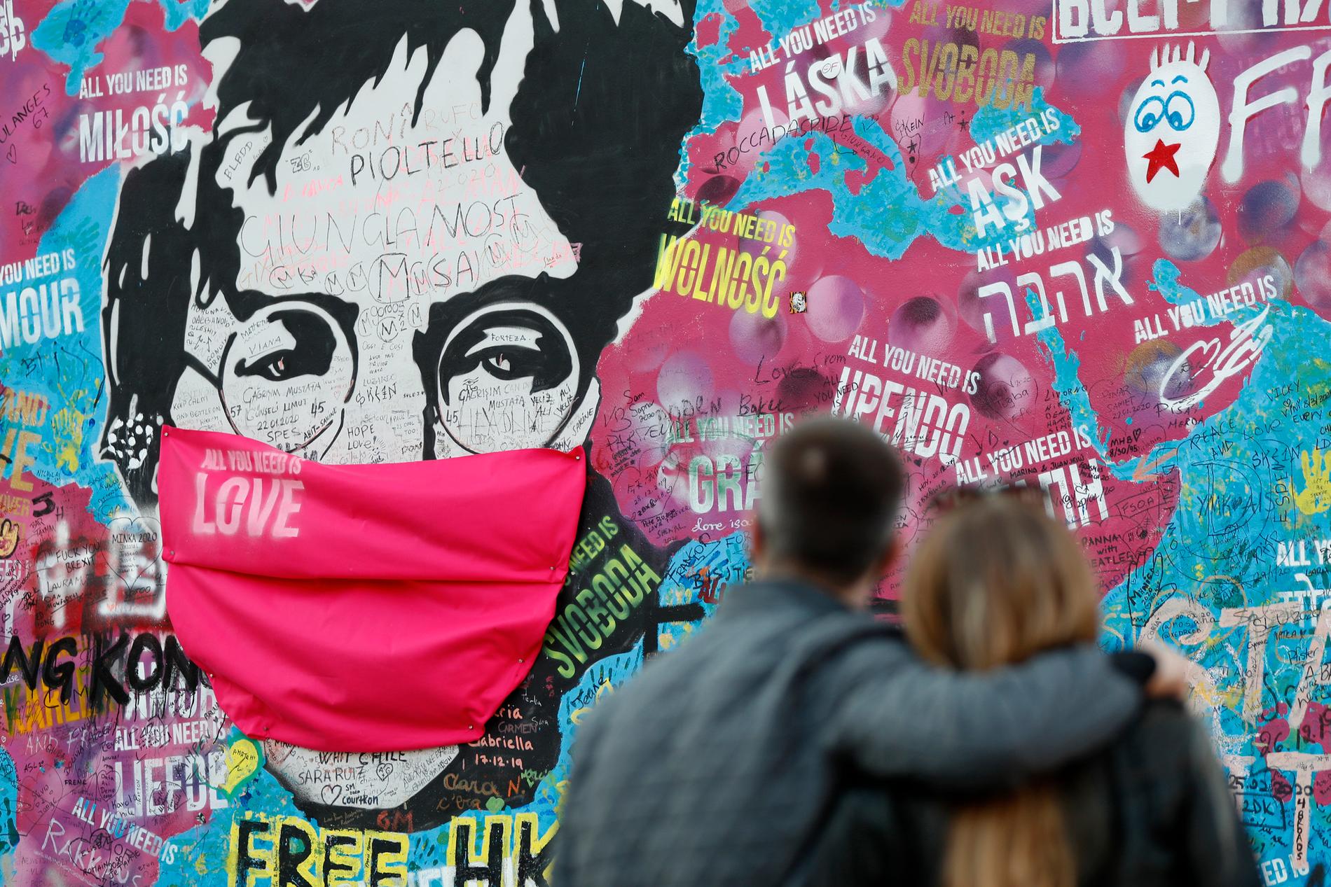 John Lennon i coronamask hyllas på en mur i Prag.
