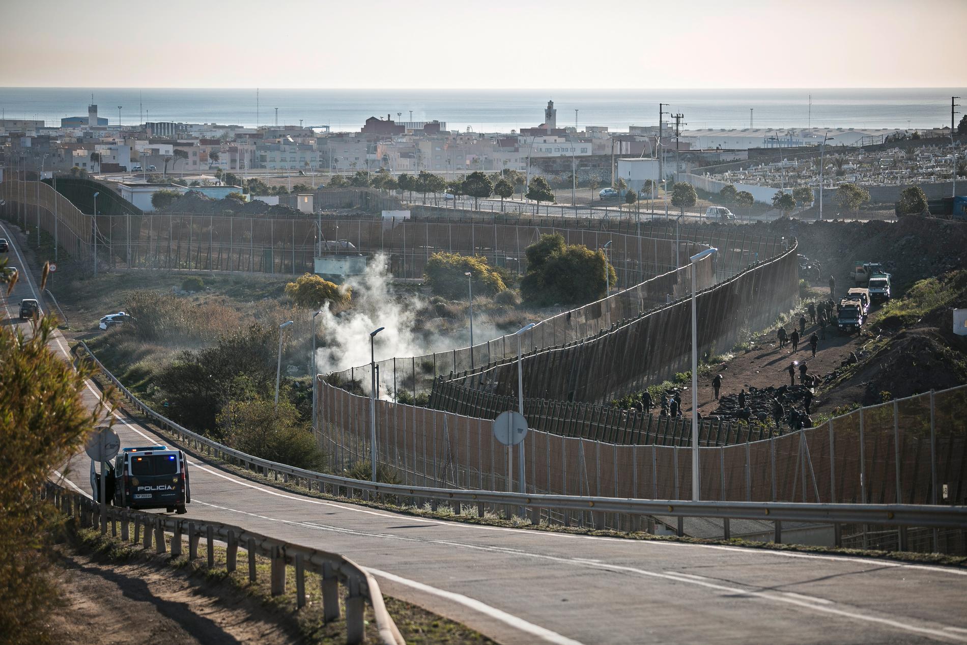 Marockanska säkerhetsstyrkor stoppar migranter från att ta sig över stängslet som skiljer Melilla från Marocko . Bilden är tagen i mars i år.