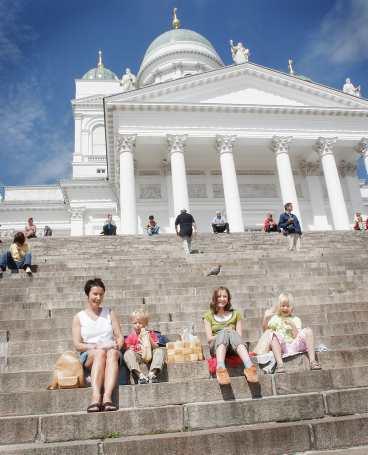 På Senatstorgets trappa smaskar Anne, Eero-Pekka, Iiris Inkeroinen och Vilkku Koskinen på jordgubbar.
