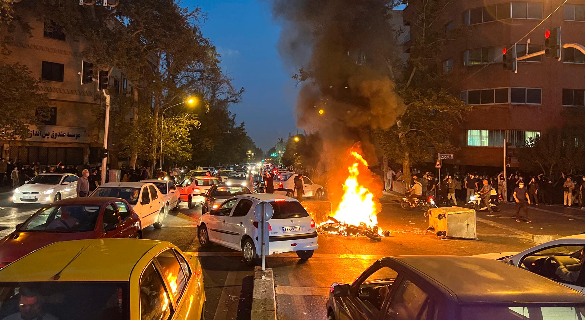 Teheran, Iran. En polismotorcykel har satts i brand under en demonstration. 