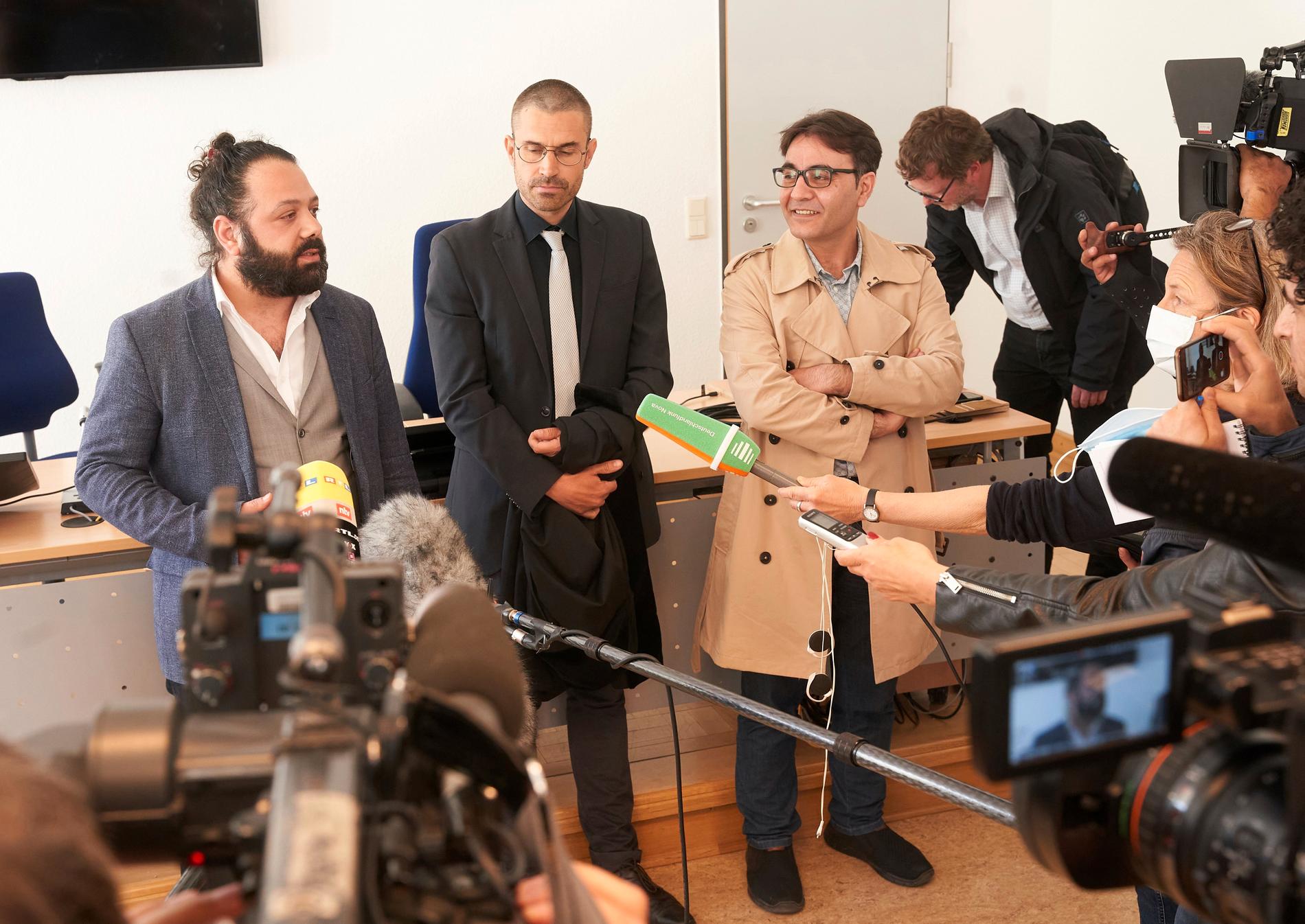 Advokaten Patrick Kroker med målsäganden Wassim Mukdad (till vänster) och Hussein Ghrer (till höger) i domstolen i Koblenz.