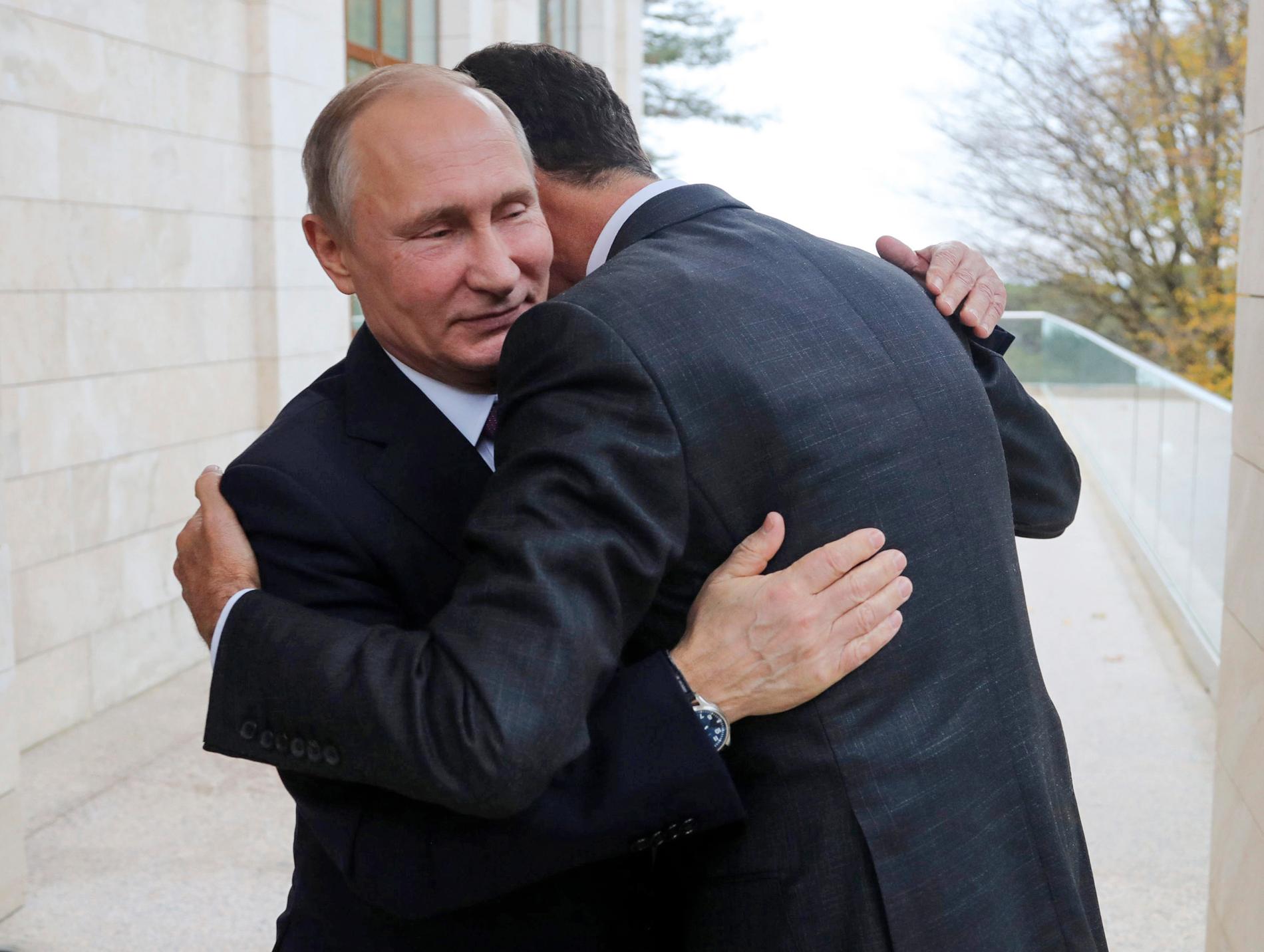 Putin omfamnar sin allierade Assad under  ett möte i ryska Sotji.