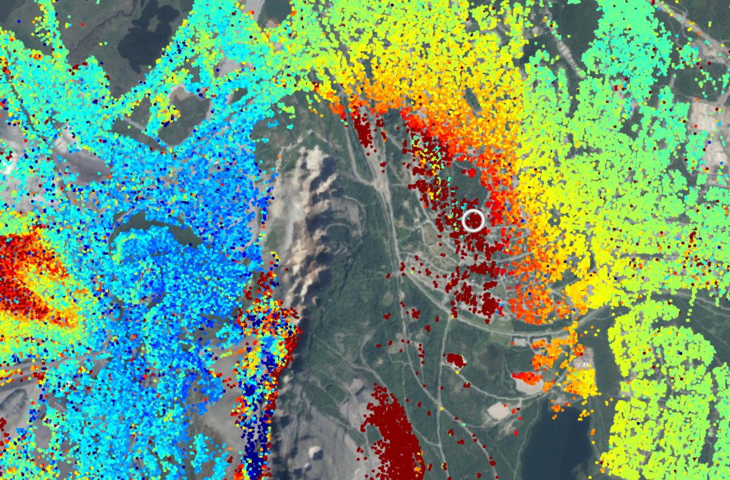 Bilden visar Kiruna och Hjalmar Lundbohmsskolan i datatjänsten Insar Sverige. De olika punkterna visar rörelser i marken, röd färg indikerar en rörelse bort från satelliten mot området för gruvdrift. Det är denna rörelse som gör att byggnaderna spricker.
