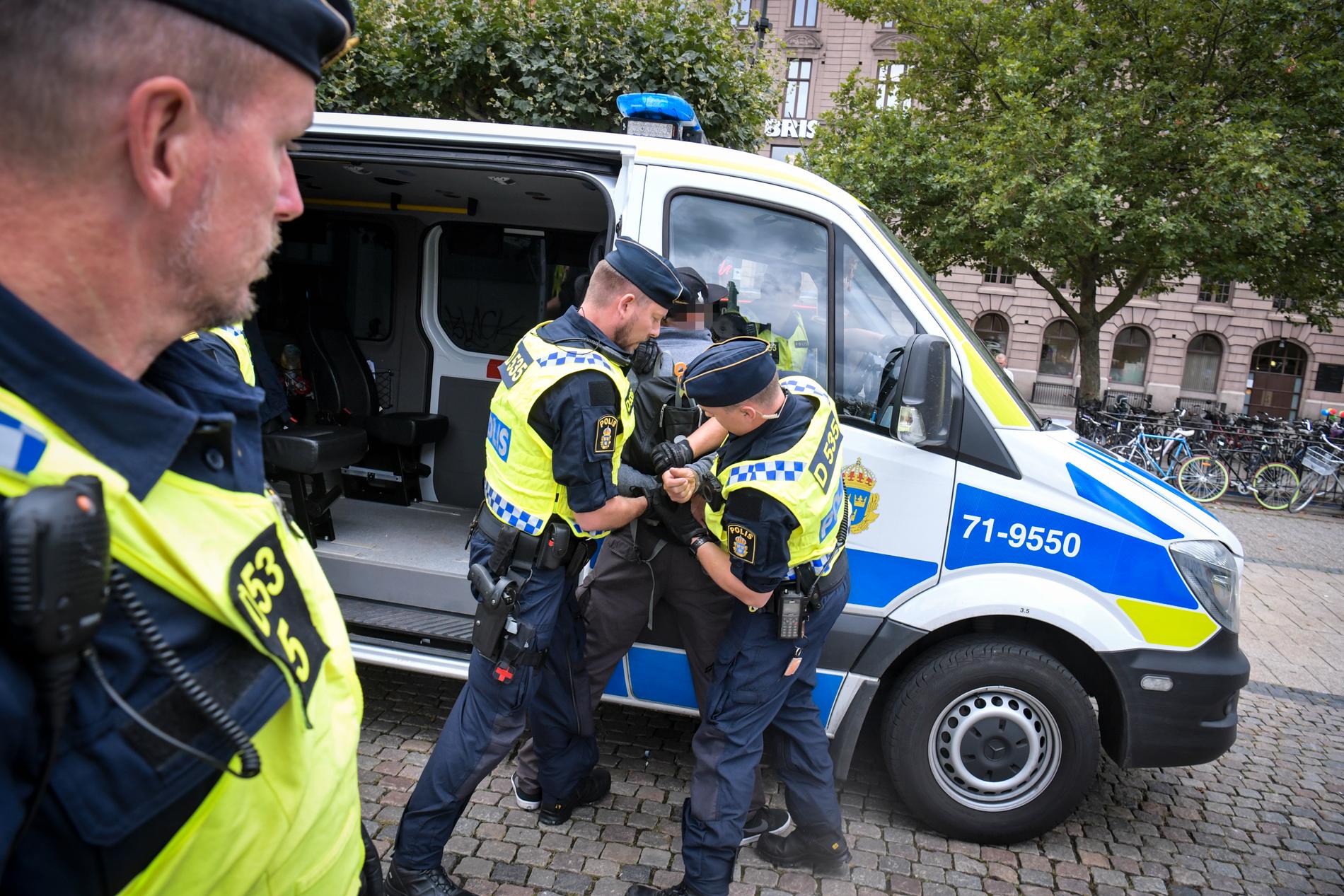 Polis griper danska demonstranter som sparkat på koranen på Stortorget i Malmö under fredagen. 