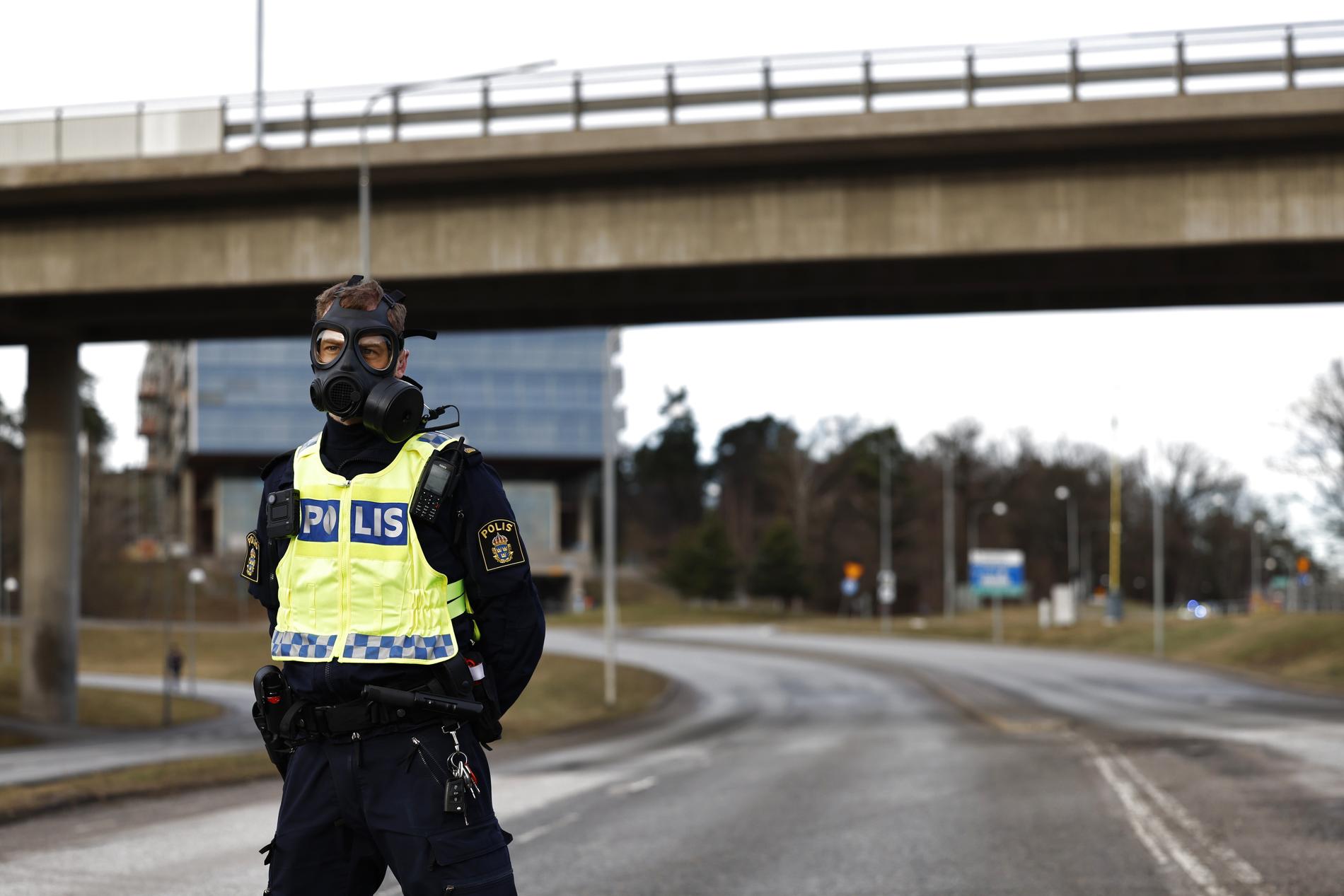 Polis i gasmask vid Säkerhetspolisens högkvarter i Solna norr om Stockholm.