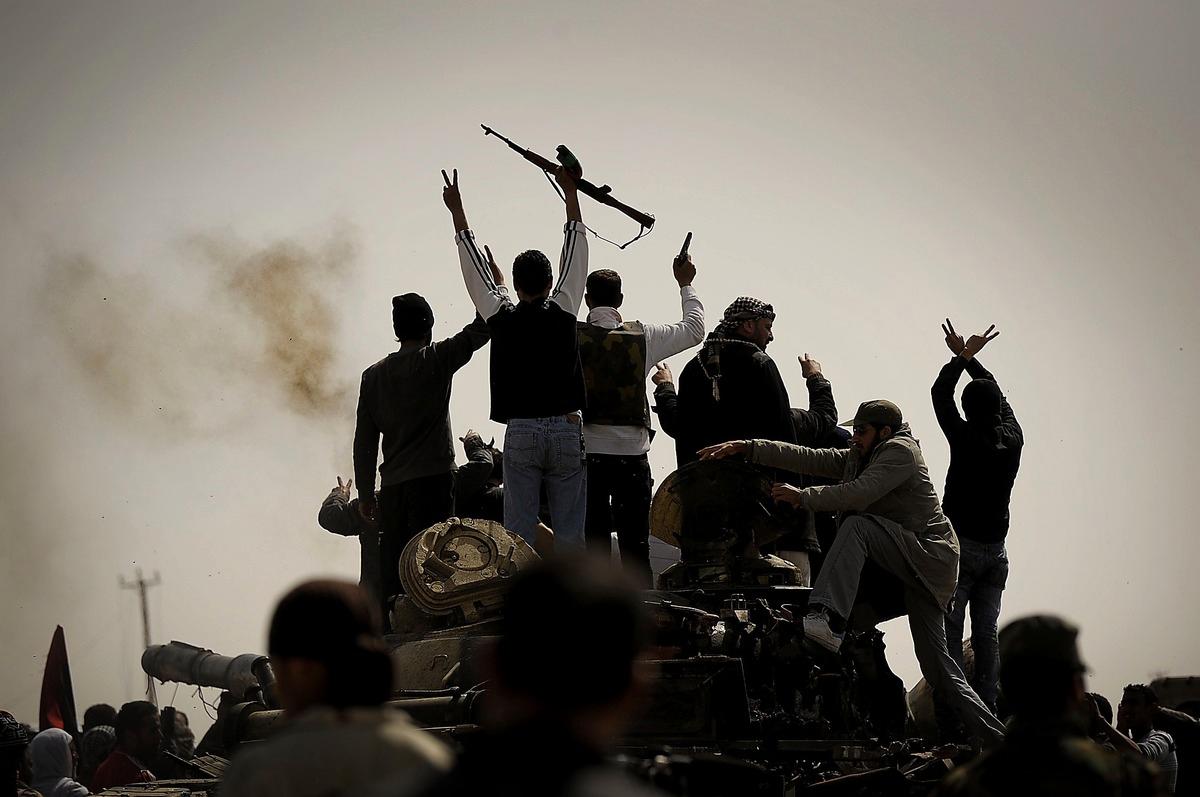 Männen i Ajdabiya bär vapen och skjuter i luften för att fira segern.