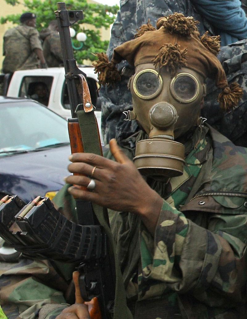 HÅRDA STRIDER En Ouattara-lojal soldat i gasmask förbereder sig inför en attack mot expresidenten Gbagbos bunker.