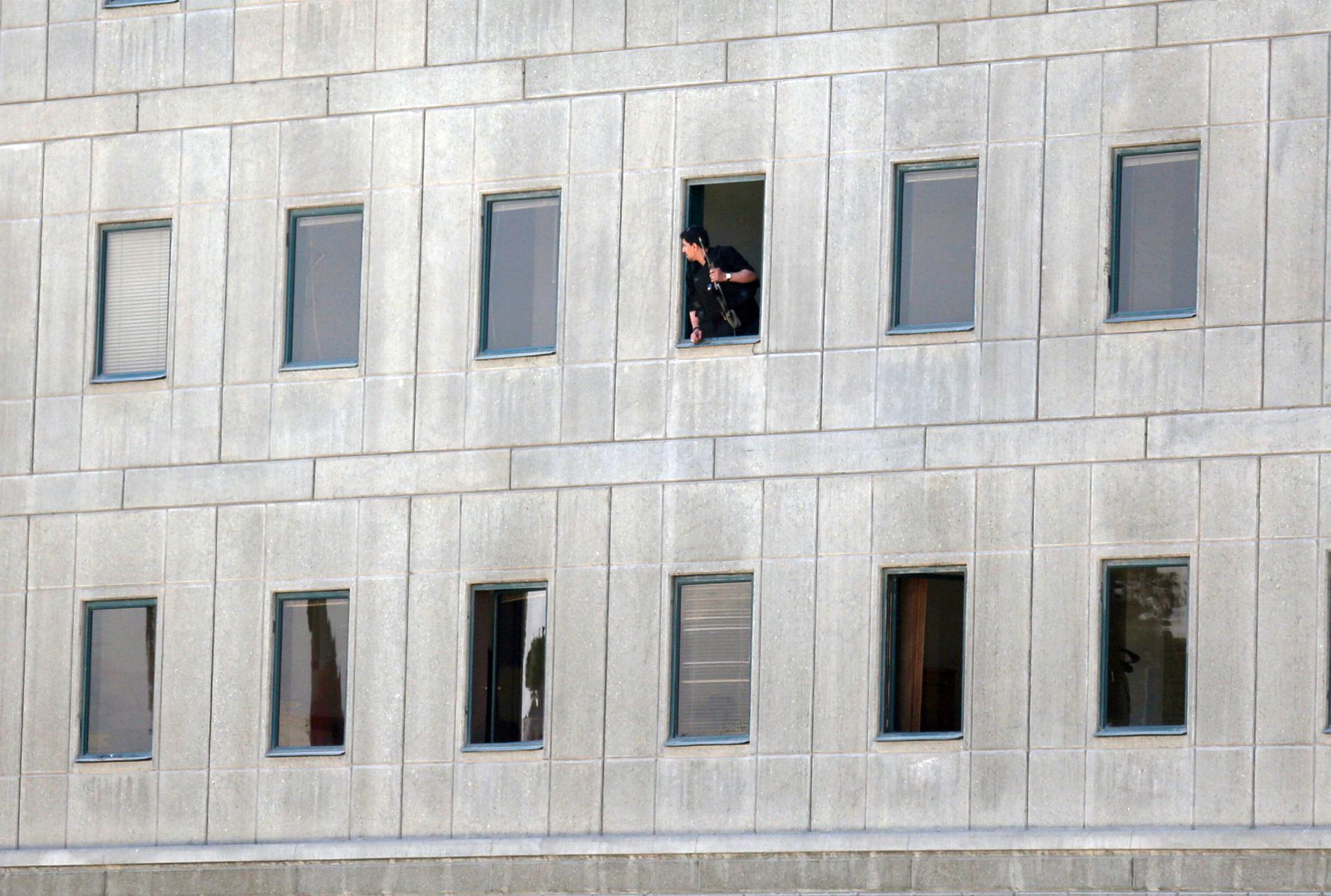 En polisman tittar ut från parlamentsbyggnaden.
