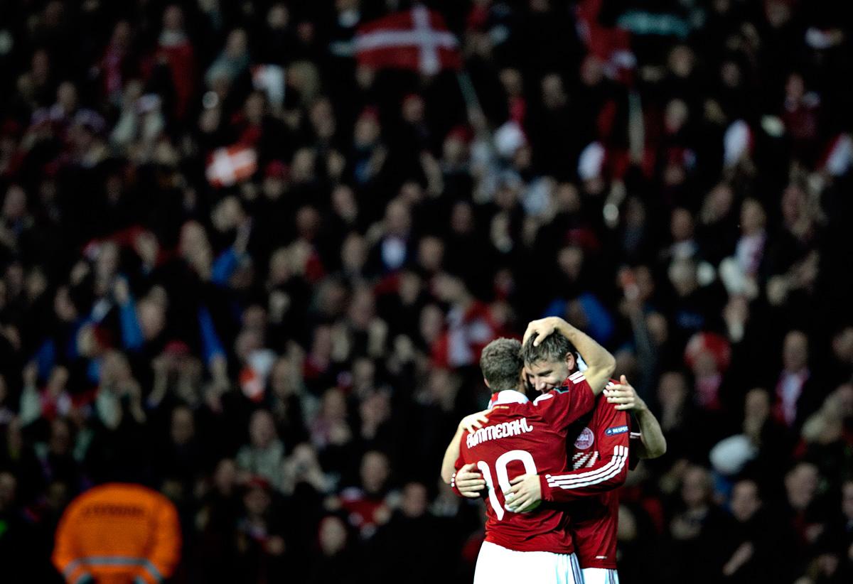 Danskarna, här representerade av Dennis Rommedahl och Nicklas Bendtner, firar EM-platsen.