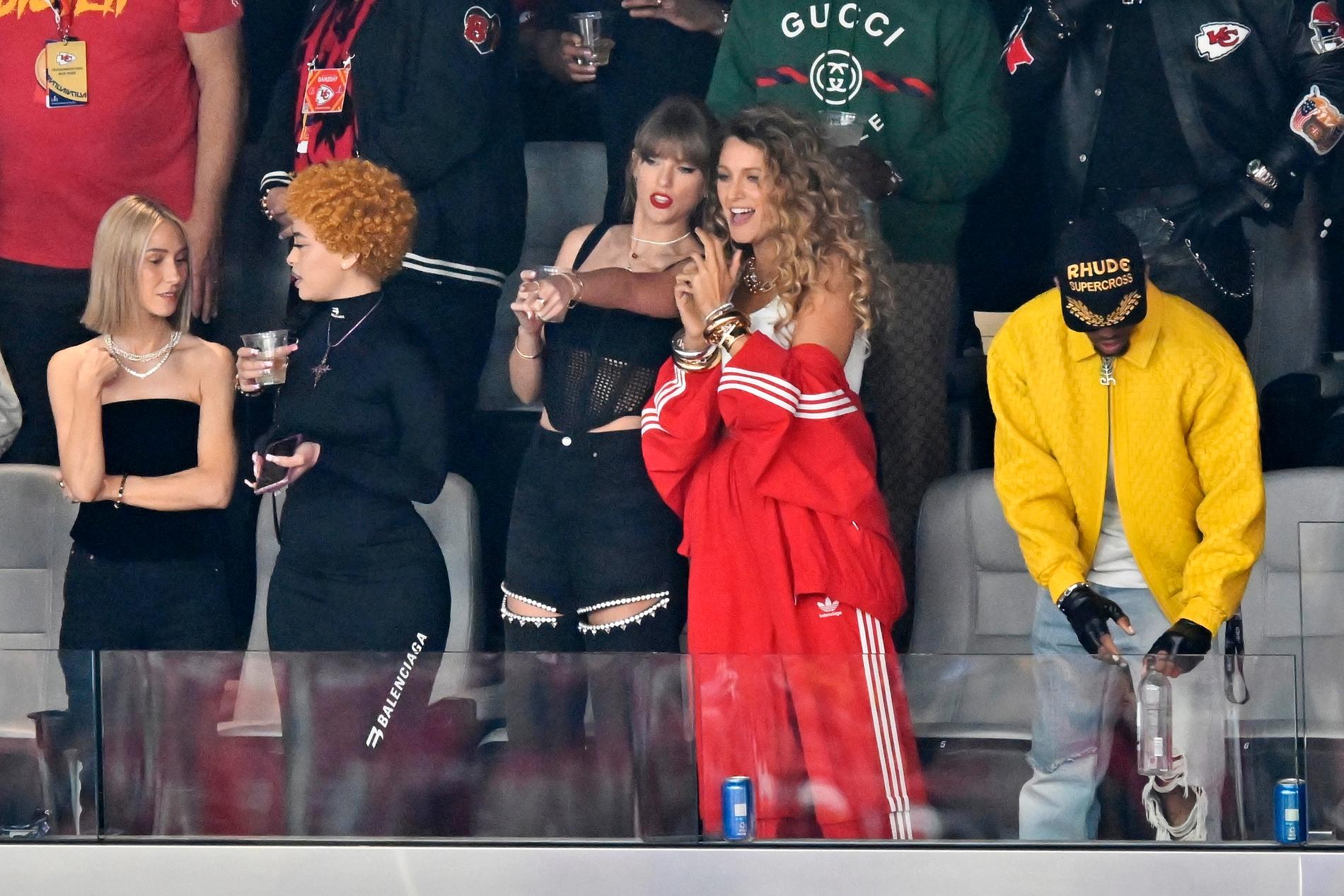 Taylor Swift, pekandes i mitten, med skådespelaren Blake Lively till höger om sig och rapparen Ice Spice till vänster. Swift är på arenan i Las Vegas för att se sin pojkvän Travis Kelce i Kansas City spela NFL-finalen i amerikansk fotboll, Super Bowl.