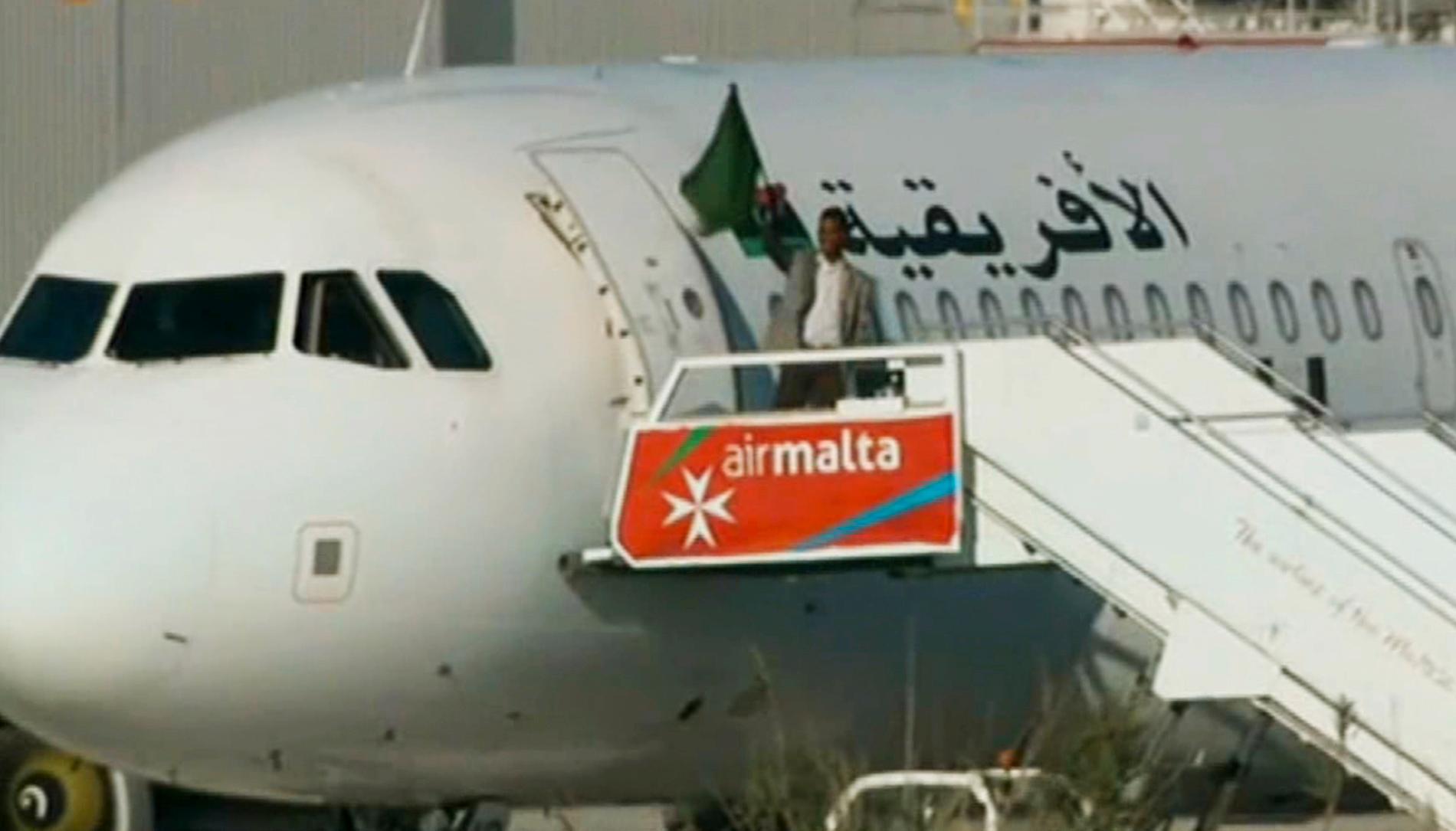 En av kaparna viftar med en flagga utanför flygplanet på Malta i december 2016. Arkivbild.