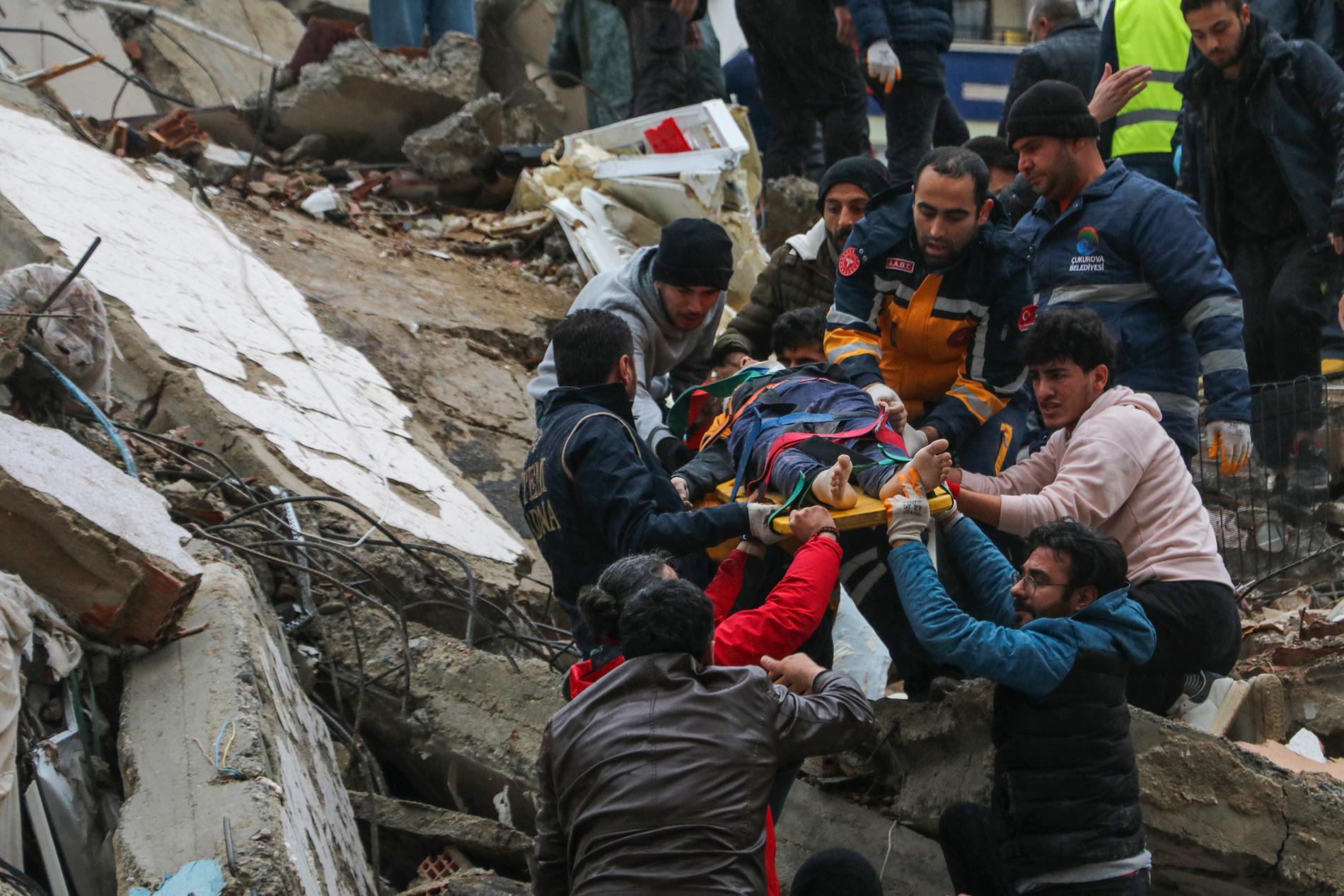 En person i Adana i södra Turkiet räddas från en byggnad som kollapsat av den kraftiga jordbävningen. 