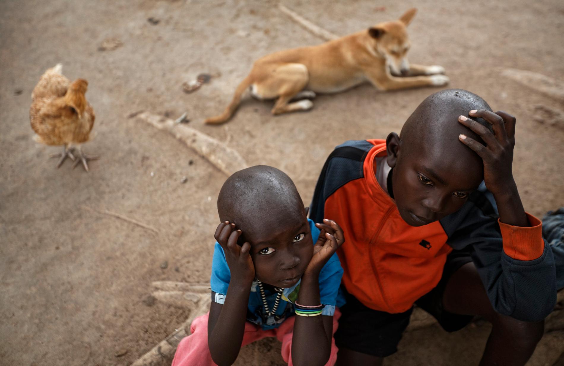 Victoria Sunday, 5 år, och storebror Abraham Wani, 7, är flyktingar från Sydsudan. Här väntar de efter att ha tagit sig över gränsen från Kongo-Kinshasa in i Uganda.
