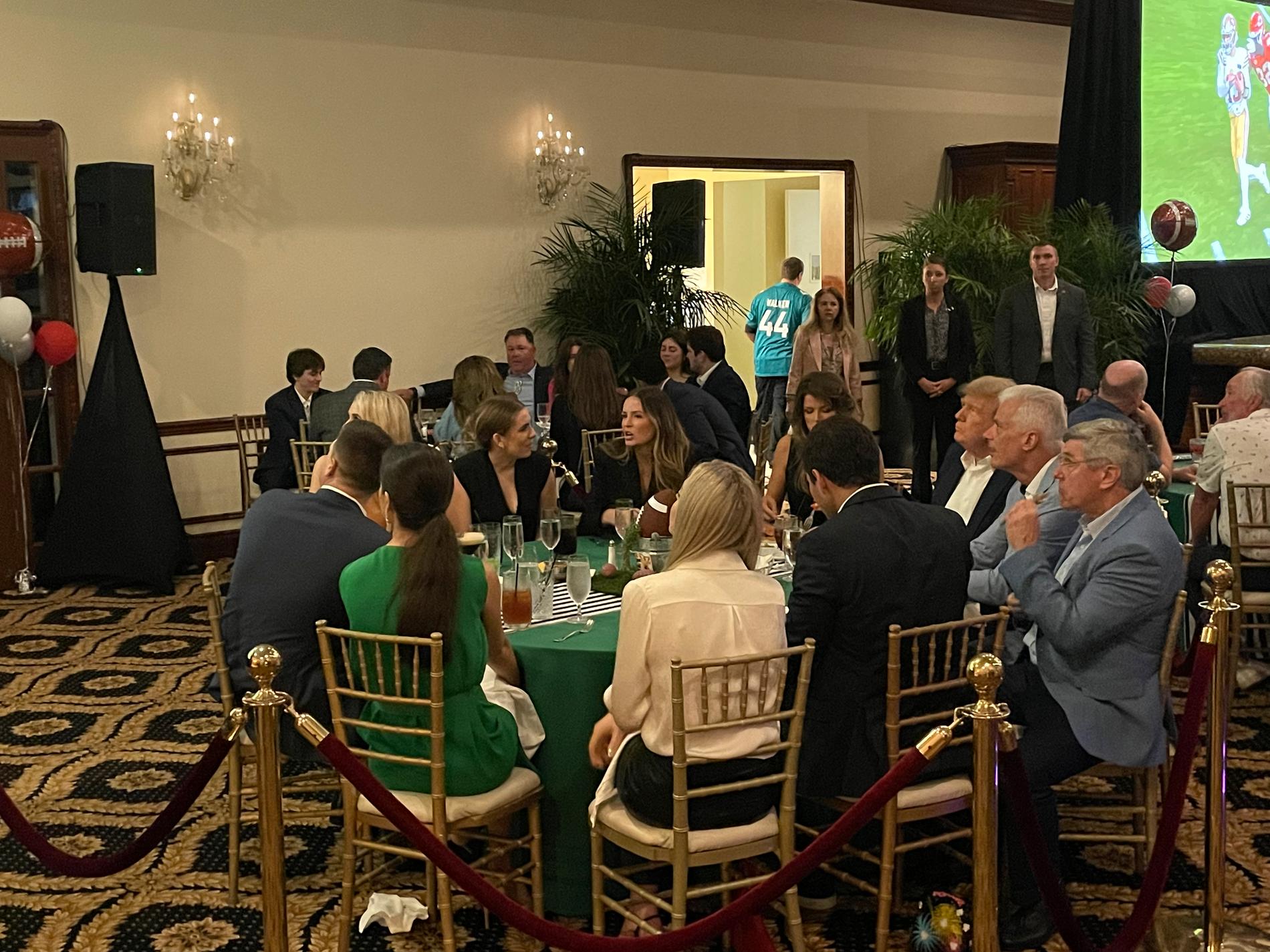 Trump tittar på matchen vid sitt bord på Mar-A-Lago. 