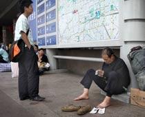 Vid Pekings västra järnvägsstation stter arbetare som har förlorat sitt jobb. De väntar på ett tåg hem.