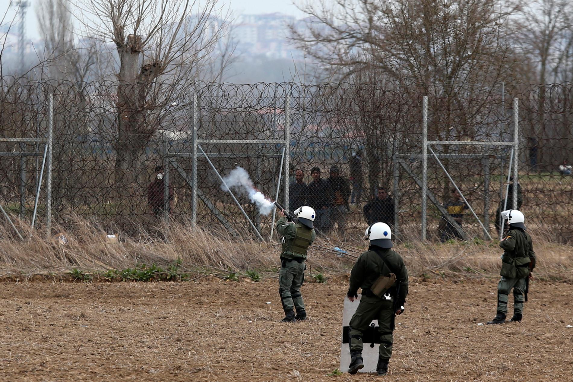 Grekisk polis skjuter tårgas mot migranter och flyktingar vid Kastanies, vid gränsen till Turkiet, under onsdagen.