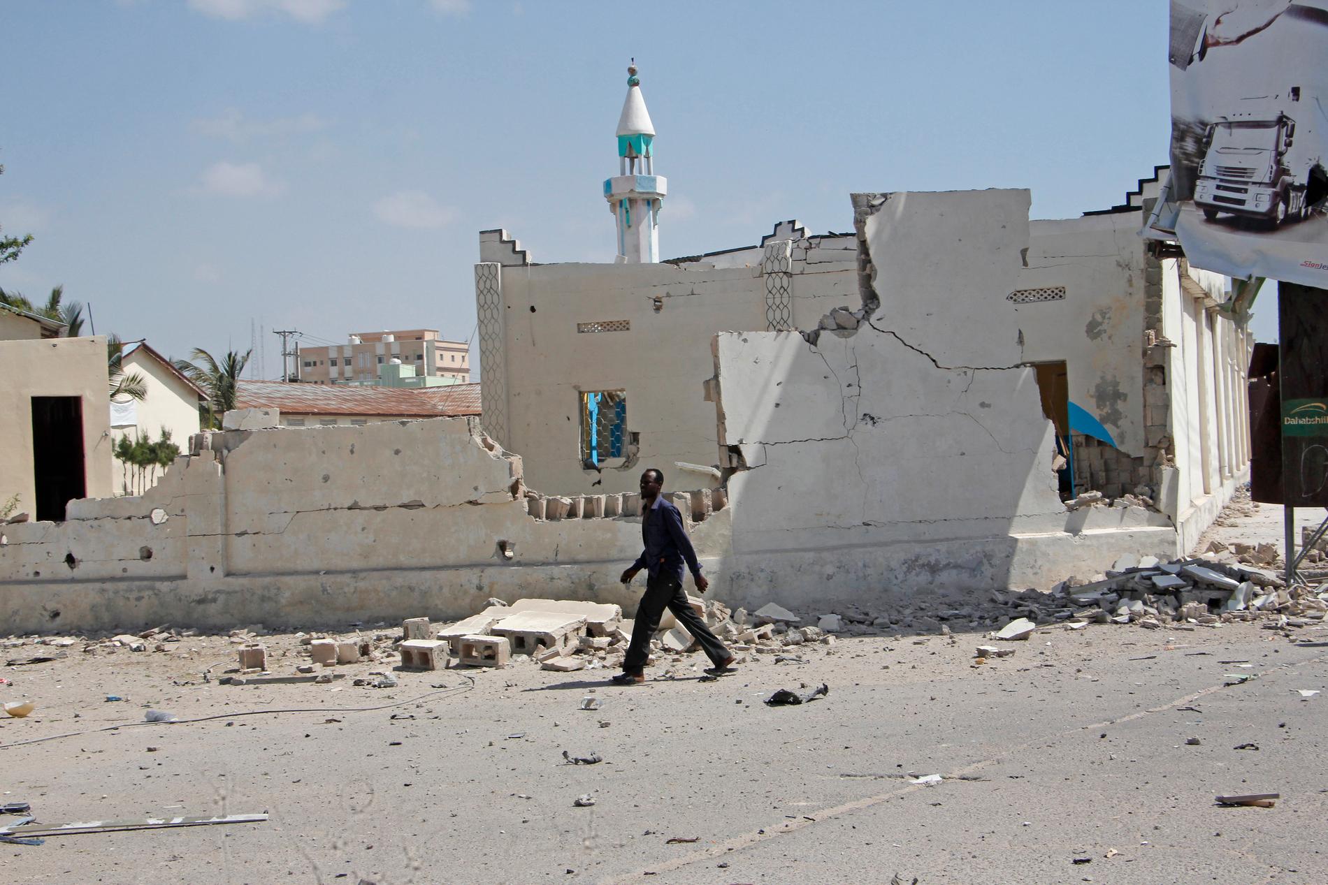 En man går förbi förstörda byggnader efter en explosion i Mogadishu. Somalias huvudstad utsätts ofta för dåd av islamistgruppen al-Shabaab. Arkivbild.