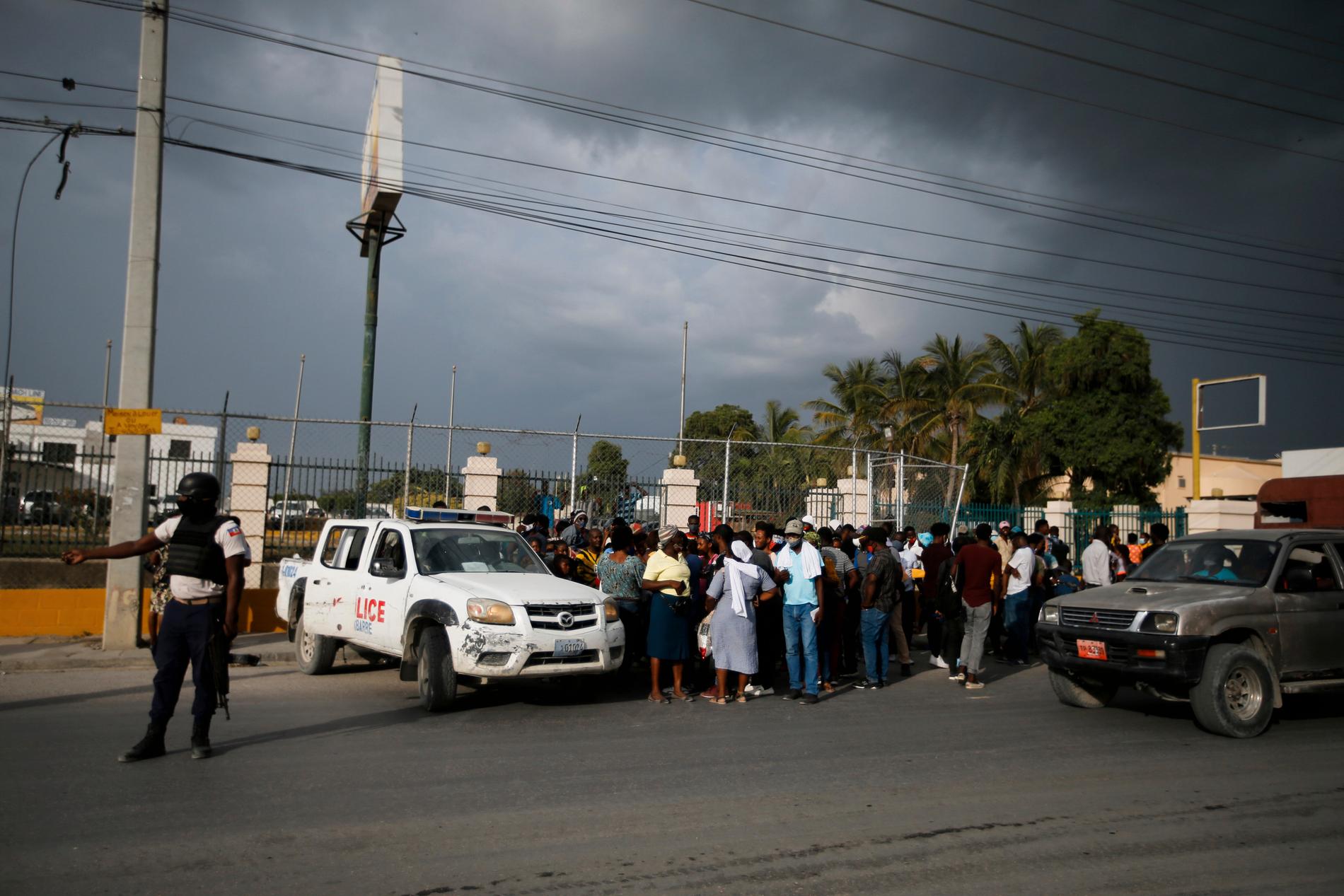 Haitisk polis stoppar folkmassor utanför USA:s ambassad i huvudstaden Port-au-Prince.