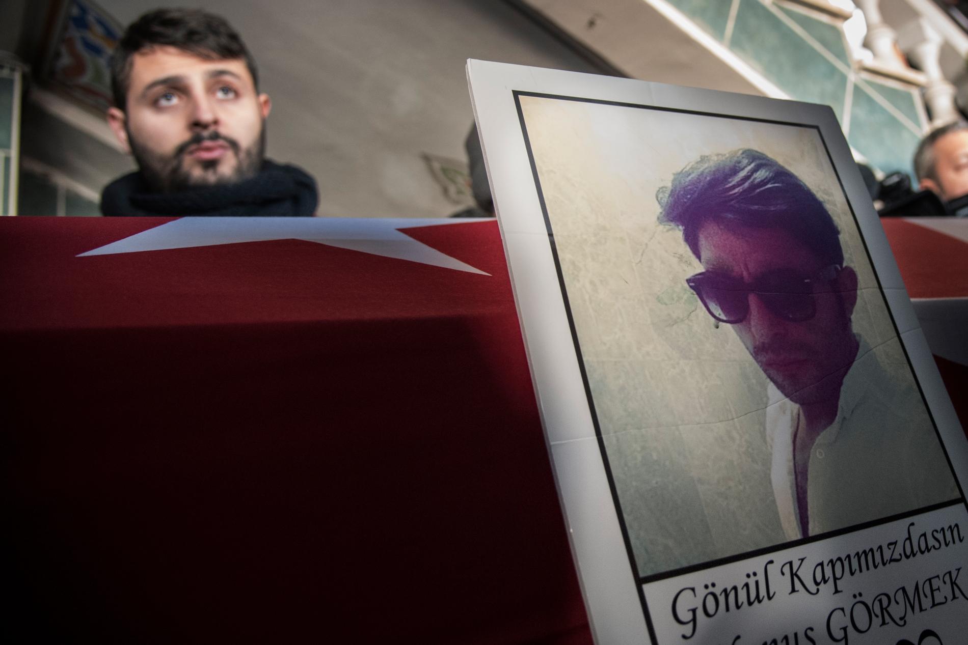 En bild av Yunus vid kistan. I bakgrunden syns en av hans bröder. Yunus Görmek, 23 var ett av den 39 offren i terrorattacken mot nattklubben Reina.