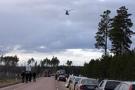 Ambulanshelikoptern på väg att landa vid olycksplatsen norr om Tierp.