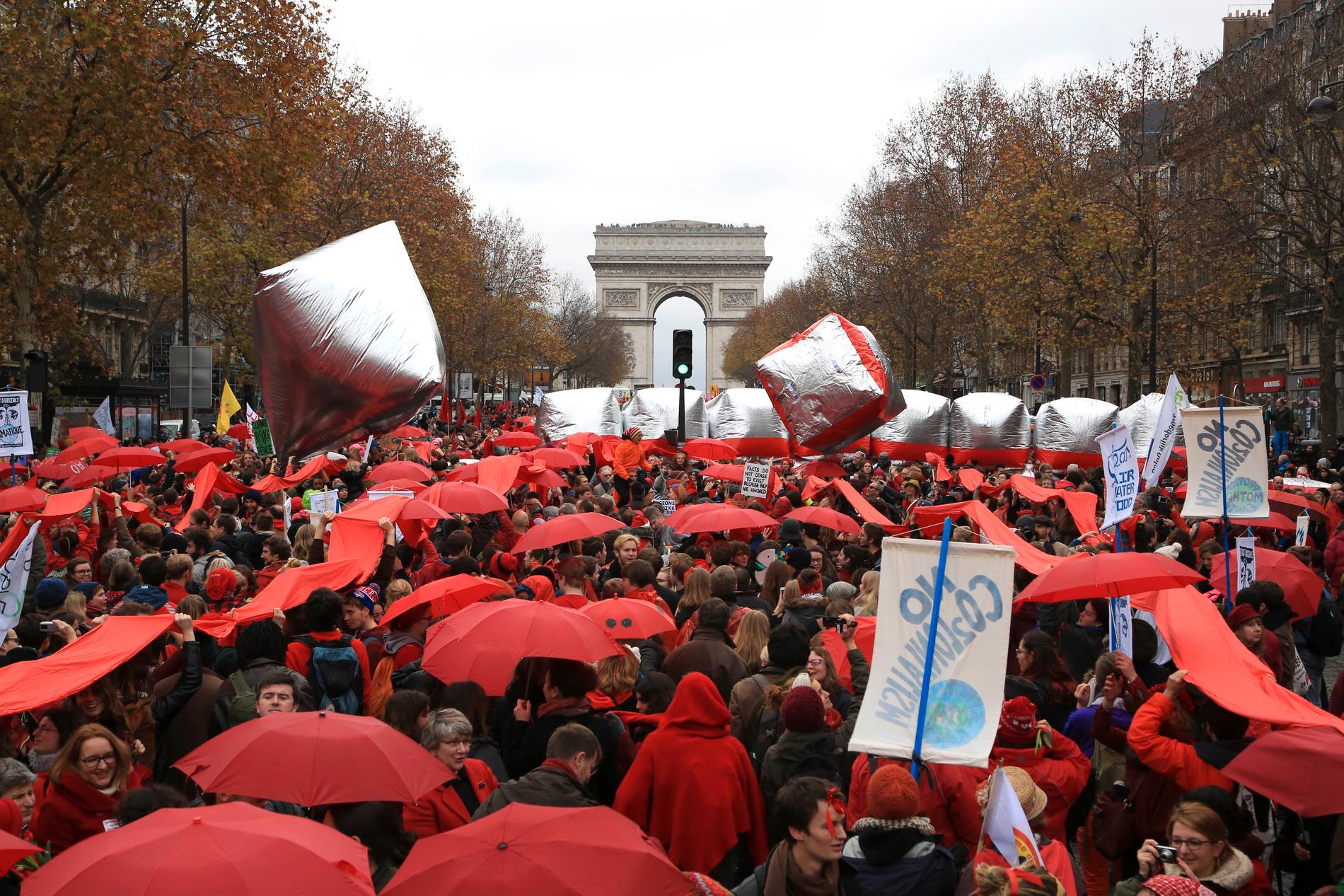 Demonstrerar med röda paraplyer under klimattoppmötet.