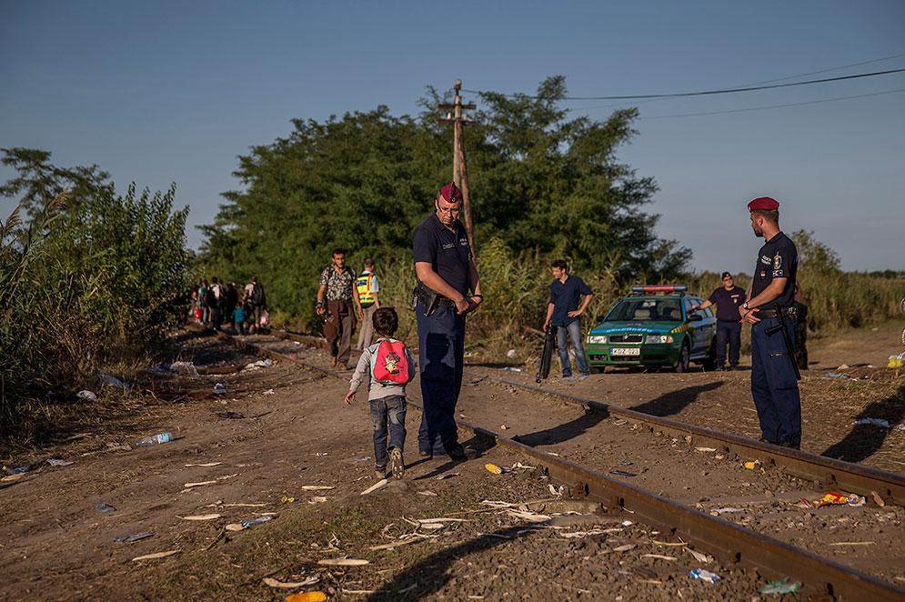 Utanför samhället Horgos går de längs med järnvägen över gränsen till Ungern. Ungerska gränsvakter släpper igenom flyktingar.
