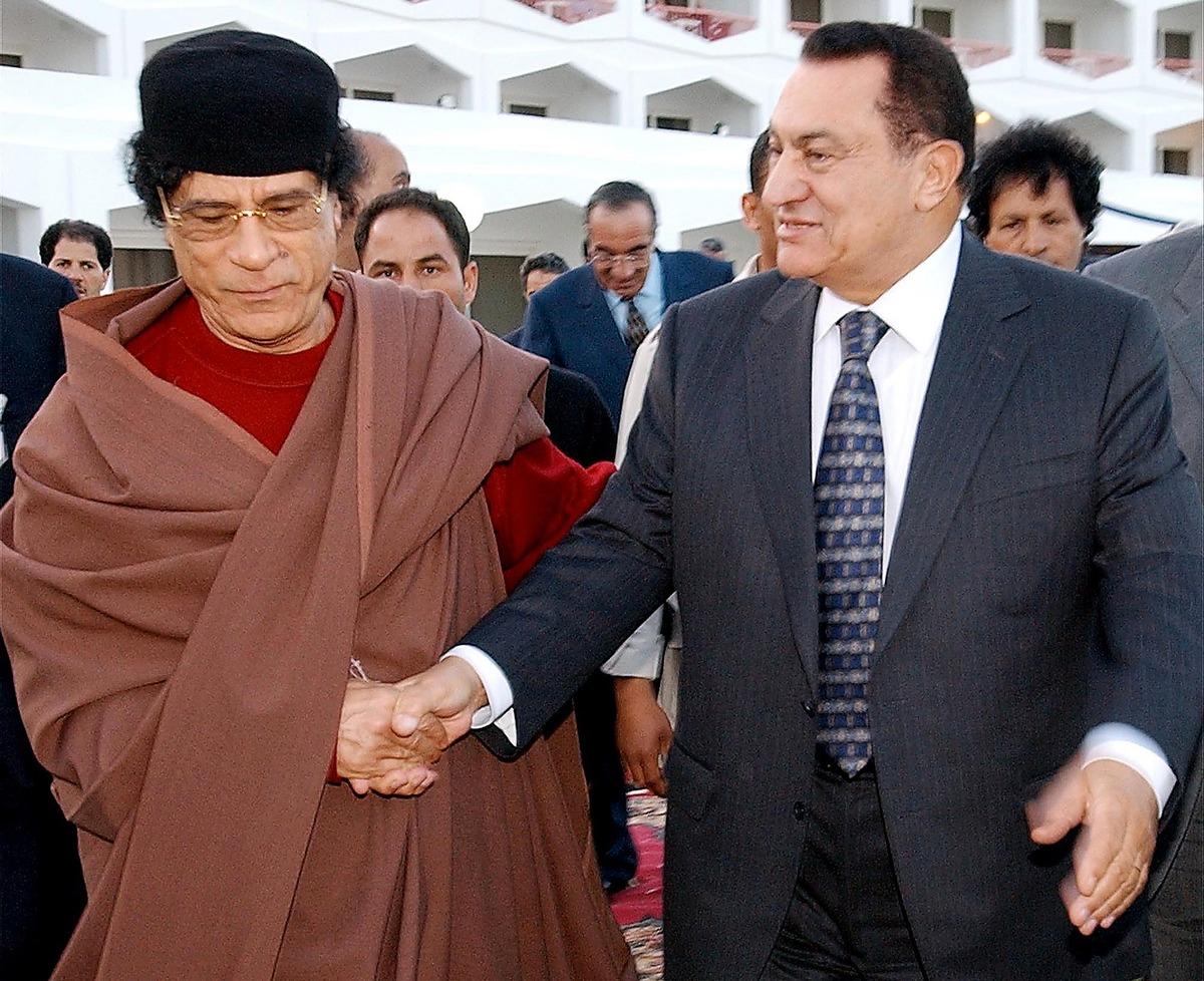 Skakar hand med Egyptens avsatte president Hosni Mubarak.