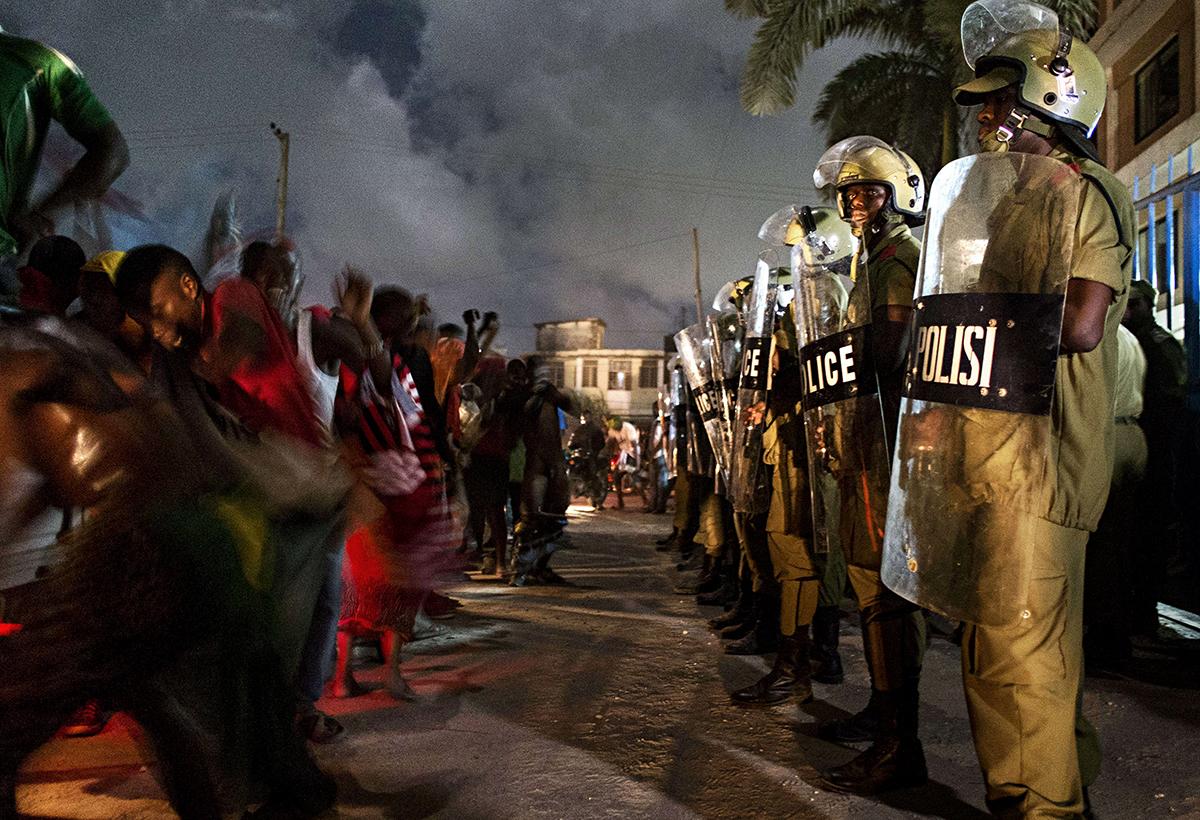 Dar es Salaam, Tanzania: Polisen står vakt för firande anhängare till oppositionspartiet Civic United Front då partiet nått ännu en framgång i landet när en av kandidaterna gått vinnande ur ett delval.