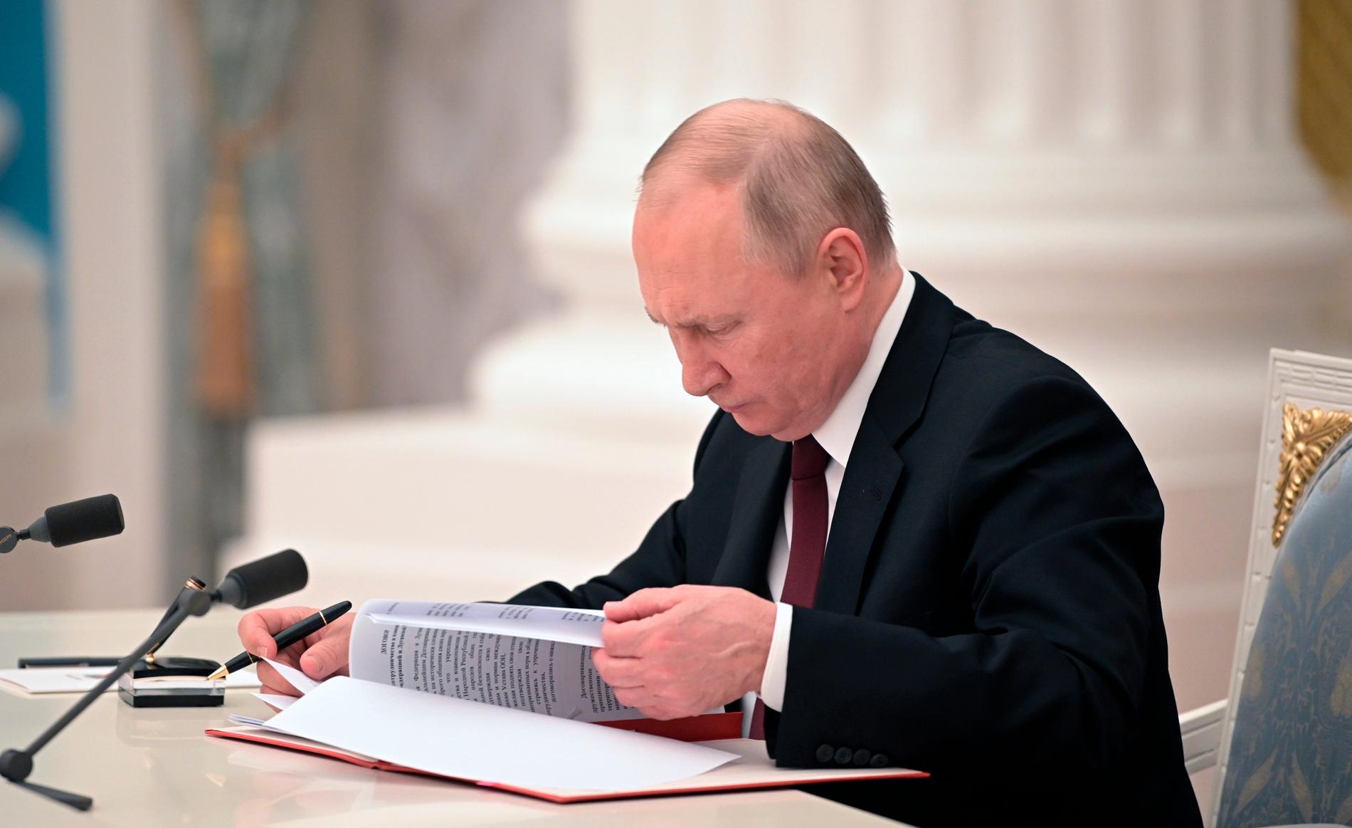 Här signerar Putin de historiska dokumenten – erkänner de ukrainska separatistregionernas självständighet.