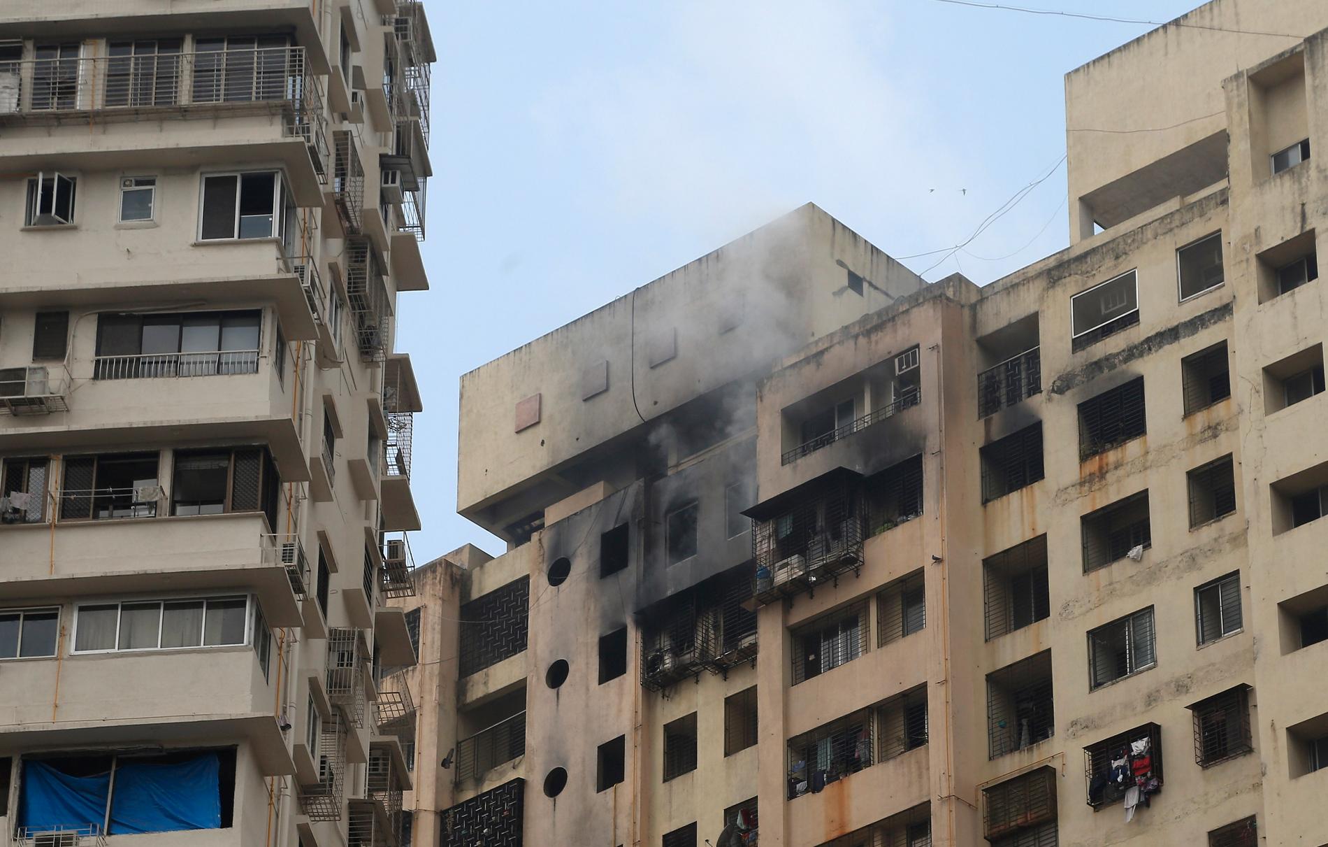 Rök stiger från en brandhärjad byggnad i Bombay. Branden tog minst sex människors liv.