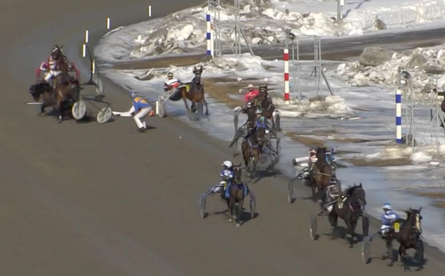 Här krockar flertalet ekipage i V65–1 på Umåker. Kuskarna Jan Norberg och Christian Månsson blev liggande på banan och får sjukvård av ambulanspersonal. Fyra hästar kom lös på banan.