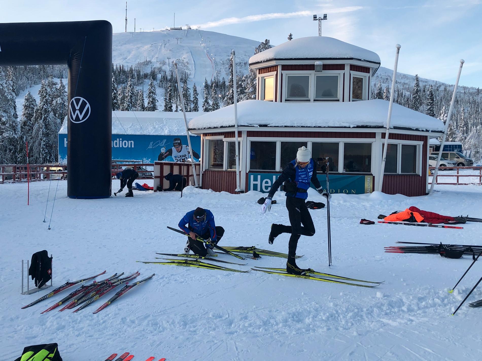 Frida Karlsson står och slår bort snö medan mamma Mia fixar med skidorna i Gällivare.
