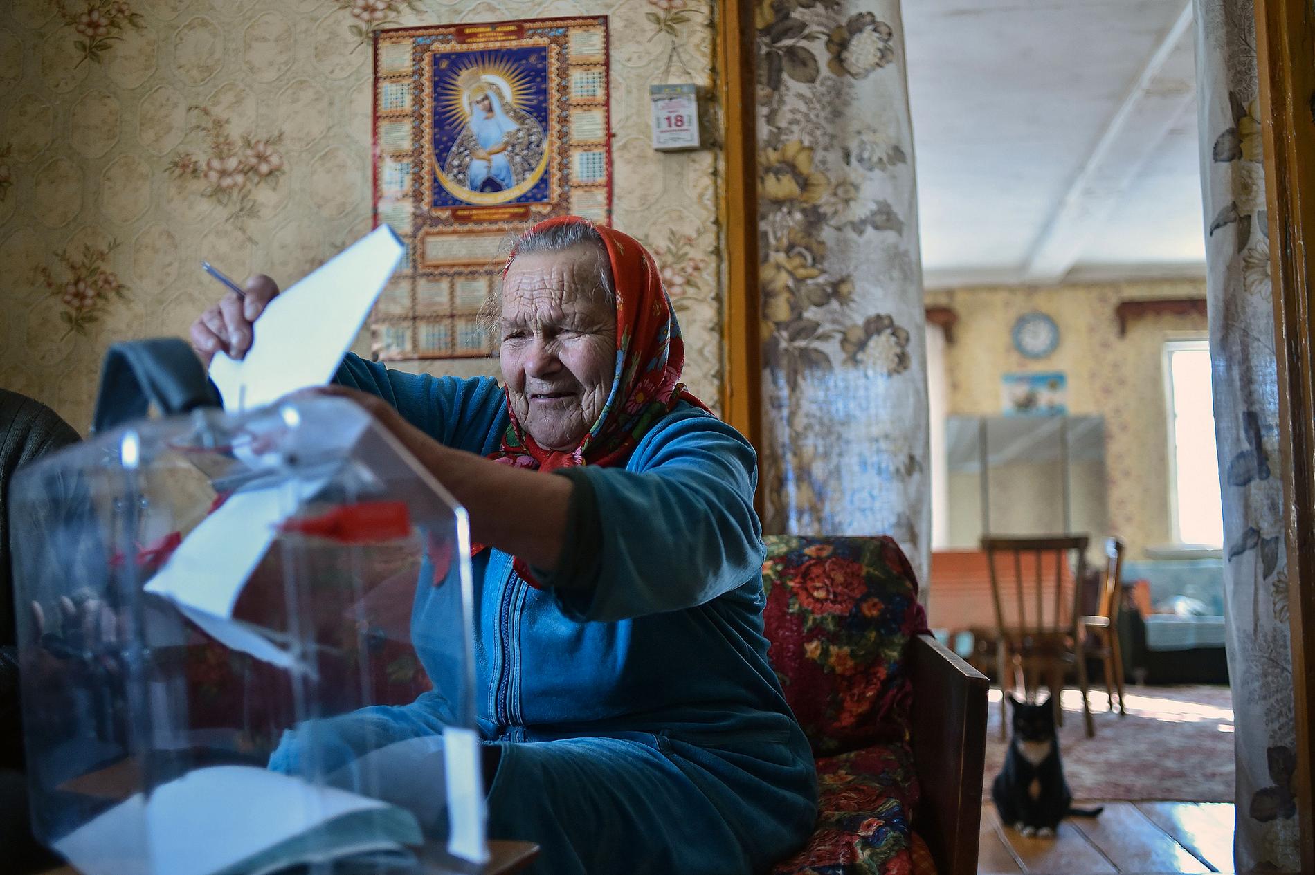 En äldre kvinna lägger sin röst hemma i Khrapovo norr om Smolensk.