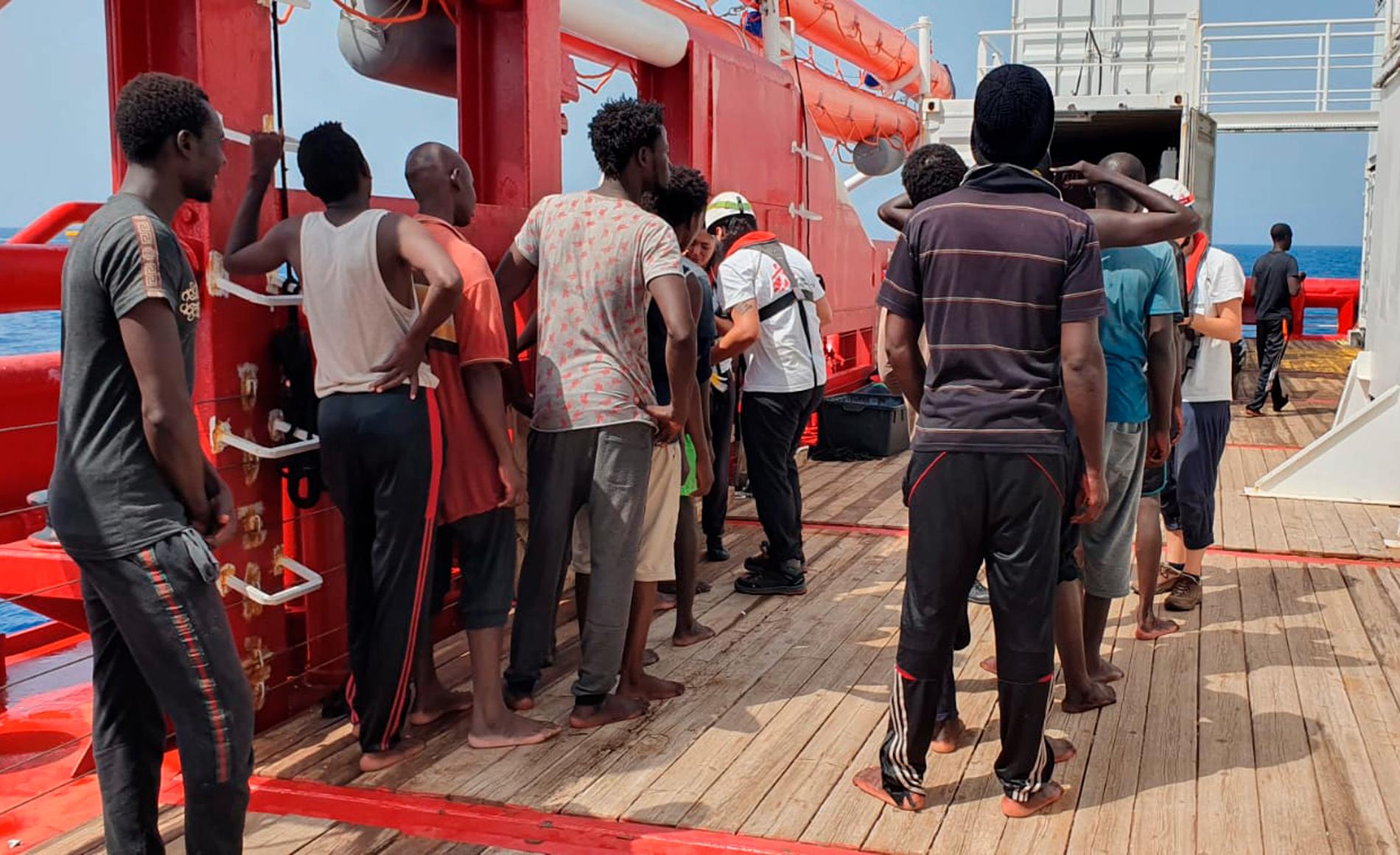 Räddade migranter köar för att bli registrerade på fartyget Ocean Viking.