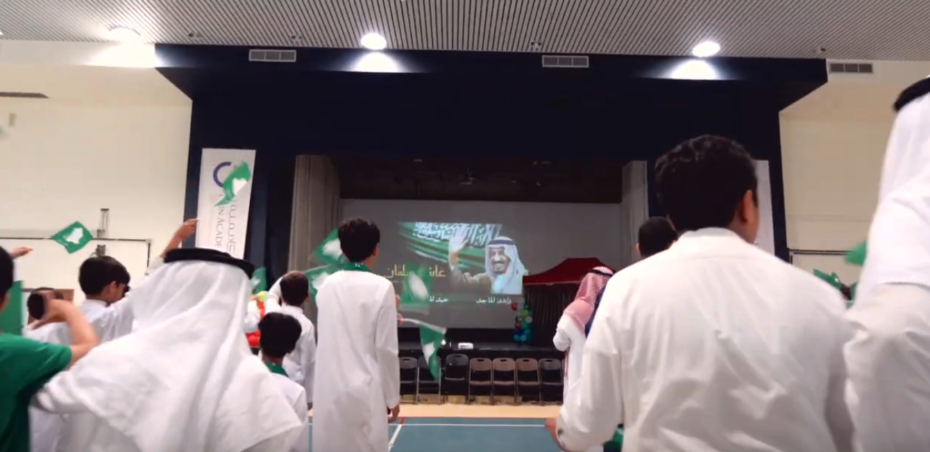 På reklamklipp från skolans national­dags­firande ser man hur elever viftar med saudiska flaggor framför bilder på Saudi­arabiens kung och kronprins – ökända för diktaturens brott mot mänskliga rättigheter.  