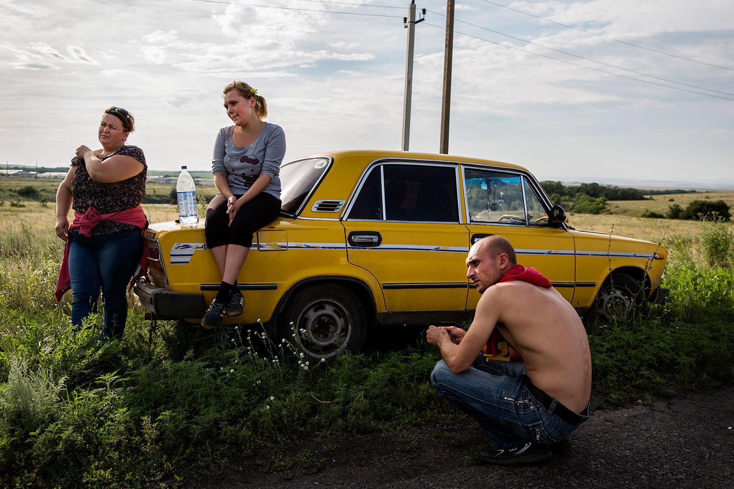 Oksana, Karina och Sergey letar efter döda på fälten kring vrakplatsen.