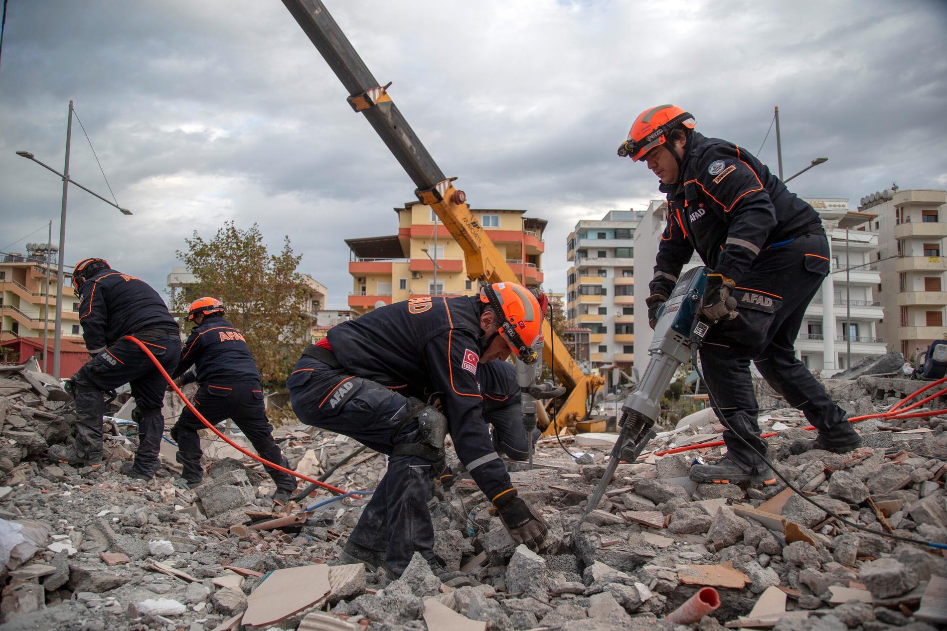 Turkiska räddningsarbetare genomsöker en raserad byggnad i hamnstaden Durrës i Albanien på torsdagen.