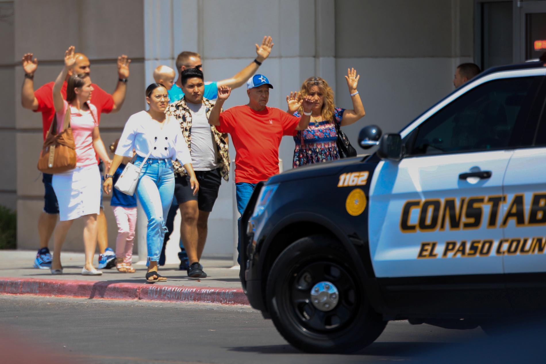 Med händerna i vädret lämnar folk shoppingcentret i El Paso, Texas, efter lördagens massaker.